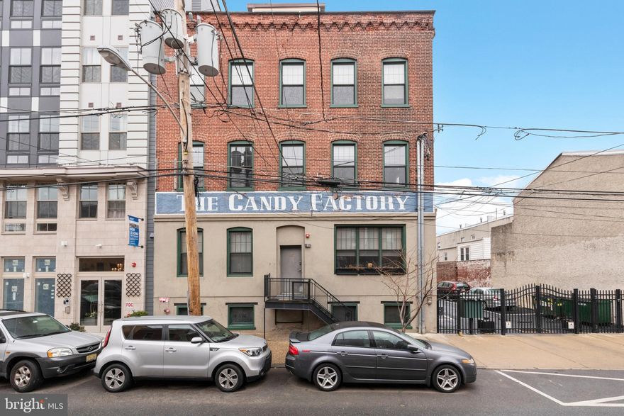 Welcome to the Candy Factory in Fishtown! Located on E Columbia ave, this 2 bed, 1.5 bath condo unit is the perfect blend of comfort and modern luxury. Entering through your private entrance into the open concept unit, you are immediately greeted by the exposed brick interior, wooden beams and the soaring high ceiling. The large open kitchen beckons you to take a seat at the island and let the chef of the family maneuver around the stainless steel appliances and granite countertops as they work their culinary magic. The pantry is an added bonus to offer additional storage and help keep your kitchen well organized. Flowing off the kitchen is a multi-use space offering plenty of room to set up a dining table as well as a lounge seating area to sit back and relax. The first of two bedrooms can be found just off the seating area, boasting oversized windows and tons of natural light. Perfect to use as a guest room, nursery, or home office this space is dynamic and can meet your every need. Returning to the main living area, the exposed brick carries through the unit showcasing large double windows that pour light into the oversized living space. Designed for entertaining and formerly accommodating a home bar, billiards table and additional seating, the living room offers you endless creative flexibility. The primary bedroom can be found off to the left. With more than enough room for a king size bed, additional seating and bedroom furniture this generously sized room offers amazing flexibility to create your own little oasis.  An added benefit of a large walk-in closet is also featured. The ensuite boasts marble floors, a double sink vanity with granite countertops and stylish light fixtures. Laundry is conveniently located in the half bath closet. Amenities to this condo offer an assigned storage unit in the basement, a parking spot in a gated lot outside of the unit, a private porch area with grill and roofdeck for condo use. A new hot water heater was also recently installed. Within easy walking distance of all the Fishtown eateries and shops, groceries and transportation, this location is absolutely everything!