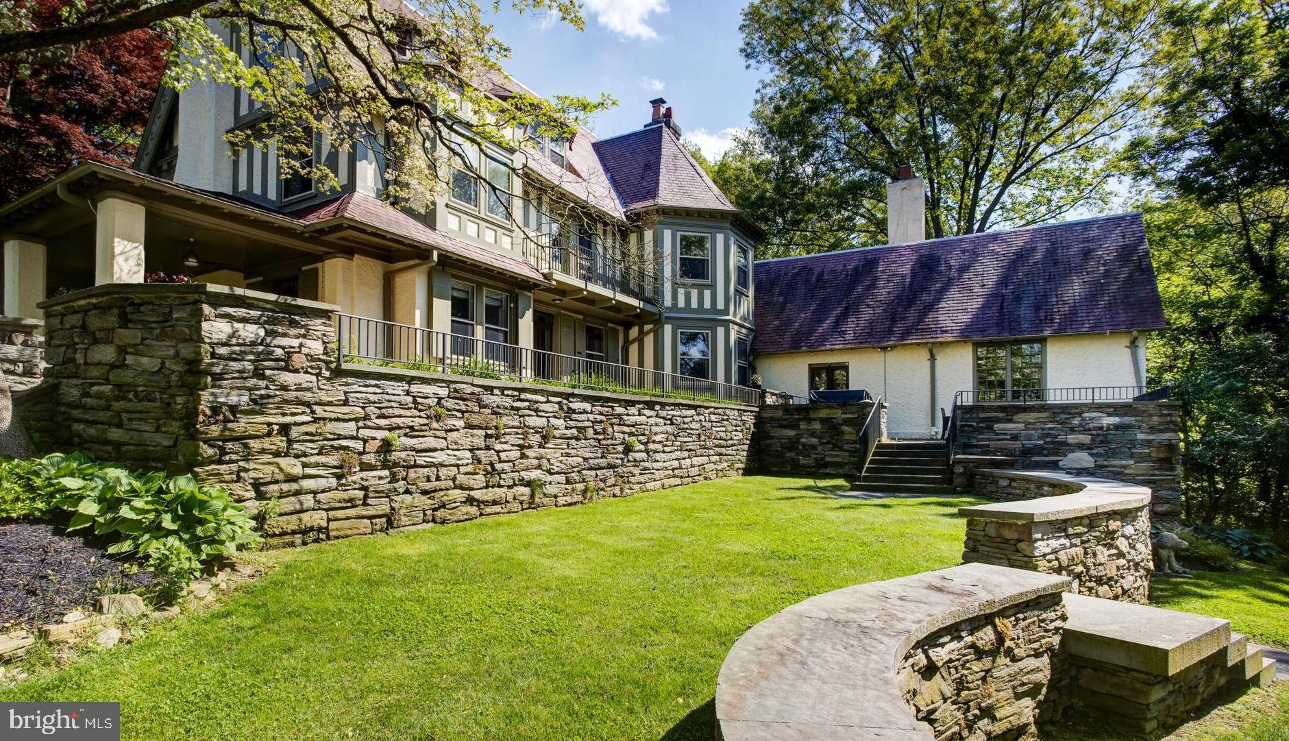 Greystock Lodge is a true architectural treasure with an exceptional blend of circa 1908 details and all of todays modern amenities. Located on one of Chestnut Hills most coveted streets, the current owners have transformed this stunning Tudor home into a private luxury oasis, perfect for entertaining and family living with lush private grounds. You are greeted with a covered walkway to the front door which opens into a grand wood-crested foyer. To the right of the foyer, you will find an expansive light-filled formal living room with a fireplace, window seating, and access to the covered patio. To the left of the foyer is a gorgeous dining room with a fireplace, beautiful built-in cabinetry (which formerly housed an expansive fish tank). Beyond the dining room is the gracious step-down great room with vaulted beamed ceilings, an oversized tiled fireplace, two walls of windows and French doors that lead to another expansive patio outdoor space with outdoor grill and storage. The bar room tucked by pocket doors between the great room and the kitchen is well equipped with a refrigerator, ice maker, dishwasher, and plenty of storage. The bright Chef s kitchen is a sight to behold, complete with a glass solarium eat-in area and an 11 foot island! The large space is equipped with a galley sink, tons of well-designed storage and pantry space, Thermador oven and microwave, 6 burner gas range, SubZero refrigerator, Bosh dishwasher, and a trash compactor. Are your shoes dirty from playing outside? Enjoy the large mudroom with tons of storage space adjacent to the kitchen. Behind the built in wine storage in the base of the beautifully ornate main stairwell is a hidden cozy den/office.The Master suite overlooking the rear grounds includes a huge spa-like master bathroom with dual walk-in closets accompanied by custom built-in shelving and drawers, a walk-in steam shower, soaking tub, toilet, and a bidet. Down the hall, there is another bedroom suite, an additional bedroom with hall bath and convenient 2nd floor laundry room with front-loading LG Washer and Dryer next to a wash sink. Continuing up the historic and grand hand carved paneled stairwell you reach the third floor noticing the built in screen from the original organ that was sounding throughout the halls of Greystock. There are two large light filled bedrooms, one with vaulted ceilings and a lofted area, a full hall bath and a sitting room on this spacious upper floor.Outside, from the stone terrace you overlook your private and well manicured tiered garden with a thoughtful landscape design that ensures greenery and blossoms throughout the growing season. Entertaining is a must-do since there is a built-in outdoor kitchen with BBQ grill with outdoor sink, bluestone patio and other terrace areas. Looking for more outdoor adventure? Enjoy the tremendous tree house that was thoughtfully built and maintained. On the property is a convenient storage shed and there is a 2 car garage steps away that is yours as well.Walk to parks, shopping and everything that Chestnut Hill has to offer and get into center city Philadelphia easily on either the R7 & R8 train lines. Virtual tour available now!