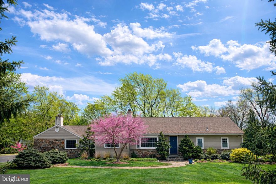 Welcome to 1408 Evans Road, a beautifully updated and thoughtfully expanded ranch home set on nearly an acre in desirable Lower Gwynedd Township. Offering 3 bedrooms with the potential for a 4th bedroom with its own full en-suite bath, and nearly 2,800 square feet of living space, this home blends mid-century modern design with Scandinavian-inspired simplicity, creating a warm, light-filled environment with clean lines and timeless appeal. An attached two-car garage adds everyday convenience.

Step inside to a warm and inviting layout where original hardwood floors flow throughout much of the home, reflecting the home’s mid-century roots. The spacious family room showcases hardwood flooring, recessed lighting, and a striking contemporary wood façade surrounding the fireplace—currently electric, but easily convertible back to wood-burning—bringing a modern yet organic focal point to the space. Just beyond, a bright breakfast nook with recessed lighting connects to the beautifully updated kitchen, featuring shaker-style cabinetry, Corian countertops with under-mount sink, stainless appliances including a new refrigerator and electric range, skylight, and a large walk-in pantry with hidden “secret” storage. A charming breakfast bar window highlights the original butcher block, adding warmth and a subtle nod to Scandinavian craftsmanship and natural materials.

The kitchen opens seamlessly to a large screened-in porch with new ceiling fans and outdoor carpeting—perfect for relaxing or entertaining—with convenient access to the basement. Just beyond, a spacious deck with new TREX decking and elegant railings overlooks the fully fenced rear yard. A thoughtfully designed kitchen window service area with a marble bar enhances the home’s indoor-outdoor flow, while a private rear gate opens directly to Gwynedd Mercy’s scenic fields and walking paths—an exceptional lifestyle feature rarely found.

Back inside, the dining room offers recessed lighting and classic hardwood flooring, flowing into a versatile front living space with a stunning stone fireplace, oversized bay window, and open connection to a flexible room currently used as a music room—ideal for a home office or additional sitting area. The home’s clean lines, natural light, and functional flow reflect both mid-century design principles and the understated elegance of Scandinavian interiors.

The bedroom wing is thoughtfully arranged for both privacy and flexibility. The primary suite features hardwood floors, recessed lighting, two spacious closets, and an en-suite bath with stall shower. Two additional bedrooms are connected by a beautifully updated Jack-and-Jill bathroom with subway tile and penny tile flooring. A fourth flexible bedroom (currently used as a playroom) includes built-ins, hardwood floors, and access to its own full bath—perfect for guests, a private suite, or multigenerational living.

Additional highlights include a full walk-out basement with laundry, water softener system, two sump pumps with battery backups, and updated mechanicals including a new Carrier HVAC system (2025) and water heater (2021). The well was redrilled in 2018 (155 ft), and all plumbing has been replaced. Two electrical panels support both the original home and the family room addition.

From the charming front approach with sophisticated landscaping and a flagstone walkway, to the thoughtful details like hidden storage, natural materials, and seamless indoor-outdoor living, this home offers a rare combination of space, functionality, and design-driven character—all within the highly regarded Wissahickon School District.