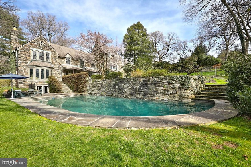 Welcome to paradise on the park, literally ! It is a rare opportunity to find a home that has quiet elegance, sophistication, and a gorgeous setting, yet a comfortable size, style, and cottage like coziness. This is that house!  Sited on a hillside  overlooking the Wissahickon, this special property offers a unique floor plan. From the front door, the entrance hall opens to a fantastic step-down living room  with pegged oak flooring, beamed ceiling, large fireplace, and an oversized window seat that is the perfect perch for watching the seasons’ change. Across from the living room, the large, beautiful  dining room can host the best of dinner parties, and has a beamed ceiling, and french doors that open to a slate terrace with custom wood slatted awning. Transitioning from the dining room is a full pantry that includes a laundry area and entrance to the sunny, eat-in, cooks kitchen, with back stairs, Italian tile flooring, Caesar Stone counters, Wolf cook top, double wall ovens, warming drawer, island with ample storage, and office nook. Every room on the first floor offers beautiful views of the multi -tiered garden. The second floor offers a flexible and unique layout that includes a master bedroom with fireplace, en-suite bath with double sinks and large shower, two large closets, and an attached study that could also serve as a dressing room or nursery. Down the hall is a second large bedroom ( presently used as a den)  and hall bath.  Continue further to the large third bedroom ,also accessed from the back stairs and easily closed off from the other rooms by a hall door. The third floor is home to a fourth bedroom, bathroom, and oversized attic storage room with cedar closet and whole house fan.This back area of the house has an outside entrance and would work well for home office, or au pair/in-law suite.Rounding out the living space is a lower level family room with wet bar, that provides easy access to the large rear patio. The grounds of this property are truly special and highlighted by a heated, in ground pool that is exquisitely configured  around a stone wall . In the evening ,with the pool lights lit and enhanced by a few flood lights nestled in the grass, it provides an amazing feature to the landscape. The property is fully fenced and hidden from view,  has a separate shed, outdoor shower, and  mature perennial gardens. This is an amazing , secluded location that is minutes from the shops and restaurants of Chestnut Hill, and public transportation yet totally private and serene. 
This home must be seen to be really appreciated.  One will rarely find a better spot.