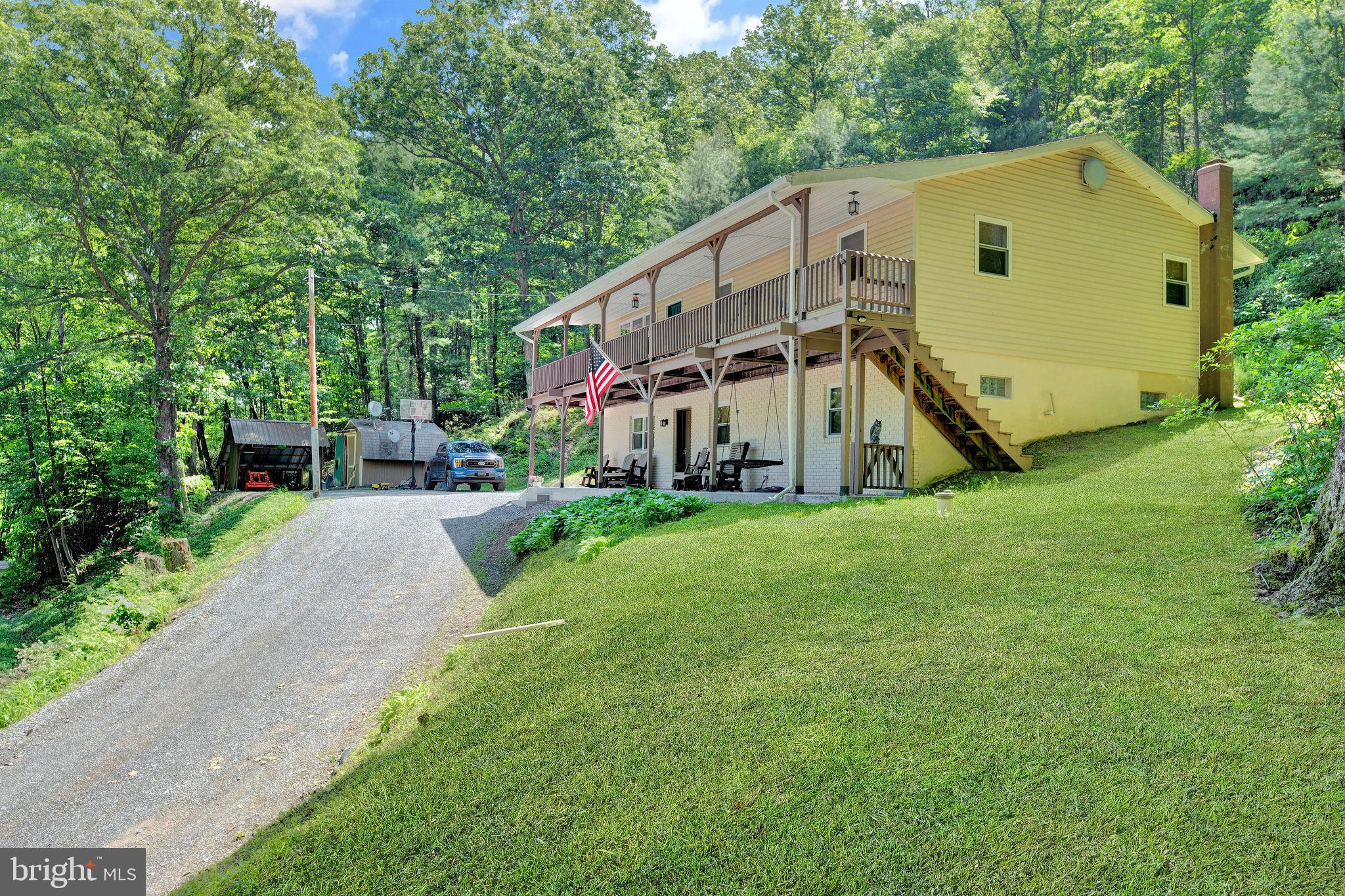 Discover this truly unique 2,500+ sqft home tucked away on over 10 acres of "Clean & Green" land rich with timber, natural beauty, and mountain views. This exceptional property blends craftsmanship, character, and comfort in a peaceful setting just 15 minutes from State College and within the Bald Eagle School District. Step inside to find handcrafted doors, exceptional masonry, and beautiful tilework that flows throughout the home. The stucco walls not only add to the charm but also offer natural insulation—keeping the house cool in the summer and warm in the winter. You’ll love the spacious rooms, cozy woodstove, and the warm, inviting atmosphere throughout. Whether you're entertaining or enjoying a quiet moment, this home offers space and serenity inside and out. Step out onto the top deck or relax on the patio as you take in panoramic mountain views and the soothing sounds of a babbling brook nearby. It's a perfect setting for nature lovers, creatives, or anyone seeking peace, privacy, and timeless charm.