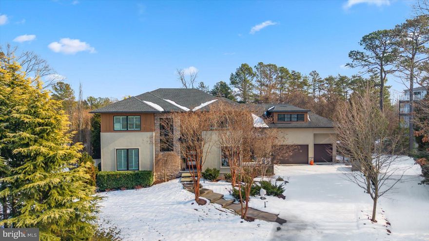 Welcome to 32 Eleanor Lee Ln. East, offering the luxury of privacy and convenience just steps from downtown Rehoboth Beach in the sought after Canal Corkran community. With over 7500 square feet of thoughtfully designed living space, there is plenty of room to relax and entertain in style. 7 bedrooms, all ensuite, including two extravagant co-primary bedrooms. Distinctive finishes abound including oak floors throughout the main floor, stone fireplaces and accent wall, and oversized sliding glass doors and custom windows bringing in light and providing views of the lush landscaping outside.  The gourmet kitchen has top of the line appliances like a 48 inch double oven Wolf range and Sub-Zero refrigerator, bar area with wine fridge, and beautiful custom granite slab countertops and backsplash. Dual gathering rooms, one with double height ceilings open to the upstairs, the second room with fireplace is open to the kitchen and dining area. An enclosed screened porch spans the rear of the house and is accessed by large glass sliders from the living spaced and first floor primary bedroom. This room showcases indoor-outdoor living, with views out back to the pool and canal, and a ductless mini-split system provides heat and A/C for year-round comfort and enjoyment. The formal dining room in the front of the house has views through large windows and a door to the covered side porch. Supplementing the kitchen is a large butler's pantry with second refrigerator, additional dishwasher, laundry, and a door to the backyard for easy access to a cold beverage from the pool area. The first-floor primary suite includes a spacious bathroom with oversized spa style shower and separate water closet, and door to a quiet nook of the rear porch. Upstairs there is a second equally impressive primary bedroom, and three additional bedrooms each with a private bath. One of these bedrooms is situated above the garage and has a heated bathroom floor and dedicated min-split system. The upstairs gathering room with stone fireplace has views to the canal and pool below. The large rear sundeck has glass railings for unimpeded views and a spiral staircase connecting to the pool area. Downstairs the finished basement has 9 foot-ceilings with two additional ensuite bedrooms, a media room, large game room, and an 8th bathroom, should you wish to use the game room as an exercise room. All this and a private boat dock with lift on the Lewes-Rehoboth Canal, private pool, Ipe wood outdoor shower, geothermal heating/air, and a three-car garage. Whether you keep this as your own private residence or take advantage of the lucrative weekly rental income, this bespoke home has everything one could wish for in a Rehoboth dream home.