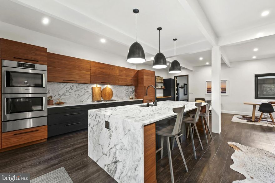 Please arrange a private showing! Welcome to 3410 Woodvalley Drive, an unrivaled mid-century modern residence where light, design, and craftsmanship come together. In 2018, the home underwent a full architectural renovation, reconstructed from the inside out with enduring comfort and no detail overlooked. Designed for long-term living rather than resale, every feature blends function and luxury. Passive-solar orientation allows winter sunlight to warm the interiors while roof overhangs limit summer heat. Inside features 10-ft ceilings, exposed beams, wide-plank flooring, and full-height interior and closet doors that stretch nearly floor to ceiling, enhancing the home’s vertical lines and airy feel. The chef’s kitchen includes Wolf, Sub-Zero & Bosch appliances, dual ovens, a five-burner gas range with custom hood, quartzite waterfall island, lift-up cabinetry, hidden outlets, and a drawer-style microwave. The primary suite offers two custom closet systems with built-in drawers and shelving, heated radiant floors, an oversized rain shower, ROHL fixtures, his-and-hers vanities, and custom blackout shades. Additional bedrooms have large windows, sliding barn doors, and built-in closet systems. The mudroom/laundry functions as a secondary prep space and butler’s pantry with deep sink, extra refrigerator, and custom cabinetry. Utility features include a full-home water filtration system and a tankless water heater. The 0.63-acre lot features full yard irrigation, original stone retaining wall with steps to the upper lawn, a six-foot custom wood fence (2023), a glass-door two-car garage, and an attached second storage garage. Architectural up-lighting showcases the home after dark. The backyard offers space for future amenities such as a pool or putting green, while preserving open green space. Modern California living, timeless elegance, and thoughtful design all come together here, a home this intentional and refined is rarely available in Woodvalley.