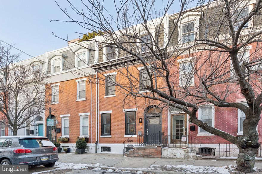 Looking for a home that combines grandeur and comfort and will stand the test of time - through the different chapters of your life? With pull-in PARKING. 4 bedrooms, 2.5 baths. Welcome to 2211 Fitzwater St, in the heart of Graduate Hospital, on a wide block that's convenient to Penn, HUP, CHOP, University City, I-76, Schuylkill River Park, Fitler Square, neighborhood pocket parks, grocery stores, Amazon pick-up center and local shops and restaurants. Admire the handsome brick front of this home that enjoys Southern exposures. Enter into an exceptionally deep and wide home with high ceilings, large windows, fireplace and space that accommodates a full dining room table and large living room furniture. Modern kitchen with stainless appliances and quartz countertops + first floor powder room + coat closet + mudroom that leads outside to the pull-in parking spot and side alley. Spacious lower level currently used as a playroom/den with wet bar; additional ample space for storage. Stairs throughout are easy, wide. On the second floor, you will find the first bedroom with windows on 2 sides and a generous closet. Walk out to a very large deck. Easily accessible so you will use it often. Also on the second floor is the grand primary suite. King bed and wide nightstands on either side - with room to spare. 2 closets and a romantic tiled bathroom with double sinks, quartz counters, a tub and separate deluxe shower. Dreamy. On the top floor, 2 more bedrooms, both with fantastic closets + laundry area + luxury tiled bath with shower/tub and double sinks. A skylight brings in lots of light. Hallways and landings throughout this house are wide and spacious (you could fit a bookshelf or desk). Hardwood on all floors. Many thoughtful features like top down/bottom up shades, plantation shutters on the first floor, electrical outlet on the deck + water hose and electrical in the back of the house. 2-zone heating. Recessed lighting. Well maintained + some new systems: heater, hot water heater, roof. A lovely home for everyday, for hosting and with room for guests to visit and have their own space. Schedule your showing today or visit one of our upcoming open houses!