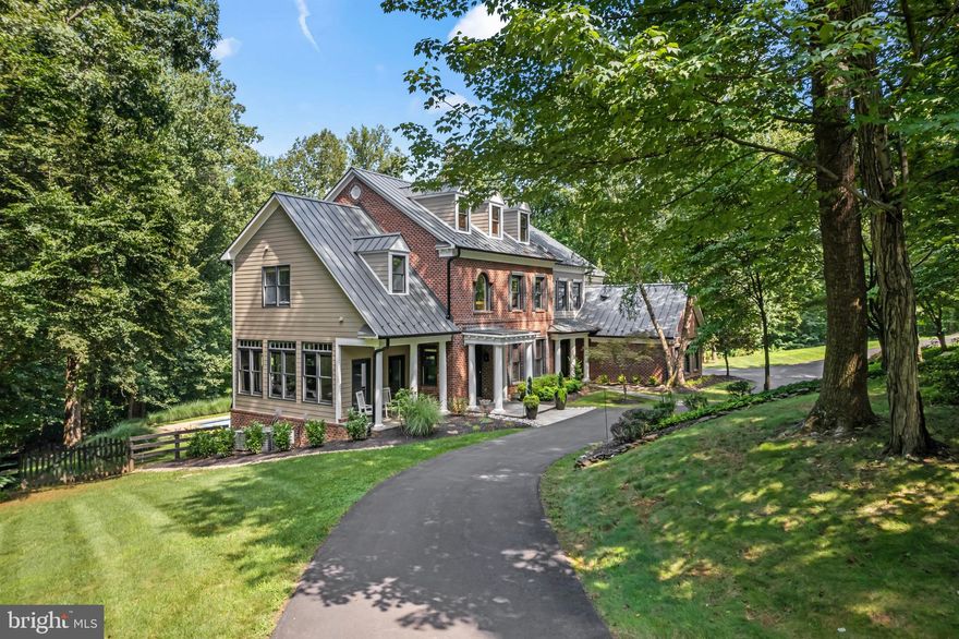 Cradled in the heart of prestigious Beacon Hill, this stunning 2024 remodeled estate epitomizes luxury living on a serene 3-acre partially wooded homesite. This custom masterpiece, featuring 5 bedrooms, five full and two half bathrooms, blends sophisticated craftsmanship and design with modern comforts for an unparalleled living experience.
Step inside to discover new Collington collection Champagne Oak hardwood floors that move you from an elegant foyer to the heart of the home. The open, light-filled floor plan is designed for peaceful living or entertaining, featuring soaring ceilings, custom built-in cabinetry in the living room, and cozy fireplaces that add warmth and charm. Expansive windows and doors frame breathtaking views of the surrounding wooded paradise, seamlessly blending indoor and outdoor living. The entire interior and exterior have been freshly painted with Farrow and Ball colors, enhancing the refined ambiance.
The dream kitchen showcases brand-new Jenn Air appliances, custom Omega quartersawn oak cabinetry, and sleek stone countertops. A spacious center island serves as the perfect hub for culinary creations, while the open connection to the family room—complete with a vaulted 12 ft ceiling, fireplace, and abundant natural light—creates a warm, welcoming space for gatherings. Adjacent, a large mudroom with custom built in lockers, offers practical storage.
Upstairs, accessed via dual staircases, the luxurious owner’s suite awaits, walk-in closets and bathroom with elegant quartz countertops and modern finishes. All five spacious bedrooms on this level offer private bathrooms, new hardwood, and generous closet space. A well-appointed upstairs laundry room with ample workspace adds convenience to daily living.
Outside, the newly installed metal roof, gutters, downspouts, and gutter guards ensure durability and low maintenance. A horseshoe driveway welcomes you home, while a rebuilt front porch, expansive wraparound back deck, private pool with new coping stones, and a backyard paver patio create an oasis for relaxation and entertainment amidst nature’s tranquility. Enhanced landscaping, drainage, and foliage elevate the outdoor experience, complemented by a new well pump for reliable water supply. New lighting fixtures throughout and remodeled downstairs half bathrooms add modern elegance to every corner of the home.
This brick estate home with HardiePlank accents, exudes custom-home sophistication. Perfectly situated near Loudoun’s finest restaurants, shopping, vineyards, and breweries, this home offers endless opportunities for leisure and recreation. Experience the pinnacle of Loudoun living at Black Gold Place, where luxury, privacy, and natural beauty converge to create a truly exceptional residence.