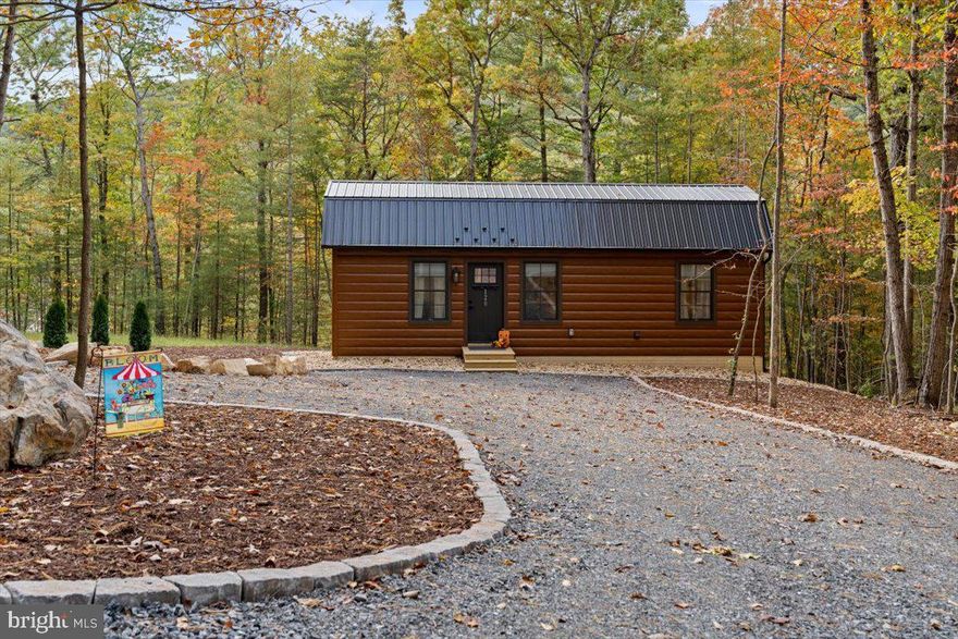 Turnkey STR opportunity with expansion potential in Luray, VA. This custom 2023-built, fully furnished 1BR + loft cabin offers approx. 700 finished sq ft and has a proven short-term rental history. Designed for low-maintenance ownership, the property features a metal roof, TruLog steel siding, spray foam insulation, Starlink internet, rear deck, propane firepit, and a 2025 hot tub on a concrete pad with stone retaining wall. Inside, the warm wood finishes, knotty pine ceilings, full kitchen with island, and tower washer/dryer create strong guest appeal from day one. The sale includes the 1.01-acre cabin lot plus 3 adjoining lots for a total of approx. 4.5647 acres. A Virginia Health Dept-approved 3-bedroom alternative onsite septic system is already installed, creating a rare value-add opportunity for a buyer—subject to approvals—to potentially add two additional 1BR tiny homes and create a 3-cabin income-producing compound. Buyer to verify all intended uses and approvals.  Owner/agent.  Agent related to owner.