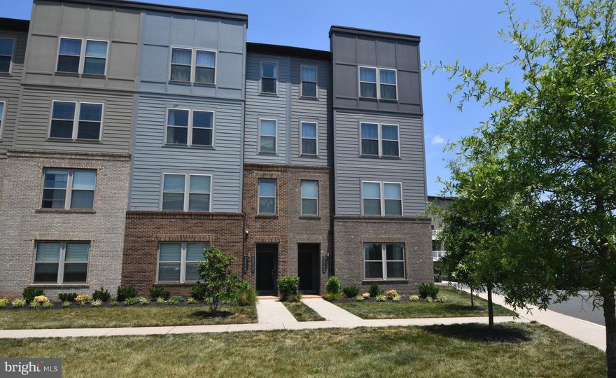 As a FORMER MODEL, this stunning, well-appointed townhome/condo offers incredible finishes and an even more incredible open floor plan!  Impeccable attention to detail... from the gourmet Chef's kitchen to the stone accent wall in the family room that adds dimension and flair!  An outside balcony/entertaining space, directly off the family room, visually extends the footprint of the main living space! The 9 ft ceilings lend themselves to the light and airy feel!  An oversized bar-height island with custom pendant lighting and plenty of seating for family enjoyment, 42" offset cabinetry with under-cabinet lighting,  a gorgeous backsplash (unlike one you've ever seen), upgraded Electrolux stainless steel appliances to include the built in microwave and double ovens are just a few hi-lights of this modern kitchen!  A 14' custom walk-in closet, ensuite bath with double vanities, frameless shower with bench seating allows you to "get away" in a spa-like setting! Two other spacious bedrooms and hall bath, with the practical and convenient bedroom level laundry is another plus! High level of smart home technology such as security cameras, smart home thermostat and a wireless access point for garage door security locks.  Enjoy the fact that the only utility you pay is electric - water and trash are included!  Ideal location 5 min. to VRE & Old Town Manassas and close to 28 , 234 Bypass, walking trails and 25 min to Dulles Airport!