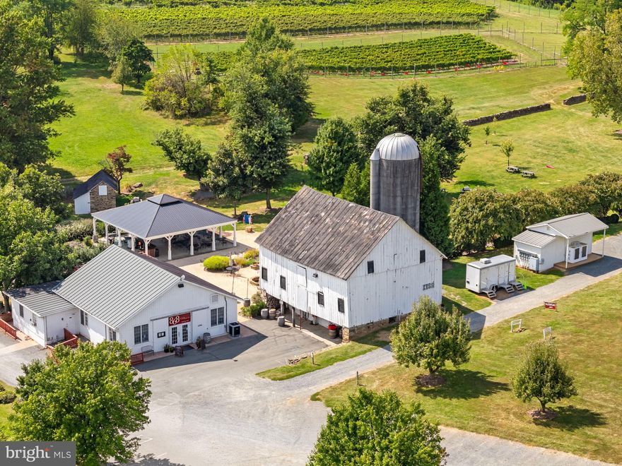 A rare and distinguished offering in the heart of Loudoun County’s celebrated wine corridor, 868 Estate Vineyards stands among Virginia’s most decorated and dynamic wine estates. Anchored by its landmark achievement as the recipient of the 2020 Virginia Governor’s Cup for its 2017 Vidal Blanc Passito, the estate continues to elevate its reputation with a remarkable series of recent accolades, including standout honors at the 2026 Virginia Governor’s Cup. In 2026 alone, 868 captured two Gold Medals for its 2023 Meritage and 2022 Meritage, along with two Silver Medals for its Cabernet Franc and Sauvignon Blanc, underscoring the estate’s consistency, craftsmanship, and depth across varietals.

Set across approximately 120 rolling acres, with 21 acres currently under vine, the property offers both immediate production strength and meaningful opportunity for expansion. The vineyard portfolio reflects thoughtful site selection and varietal diversity, with plantings that include Chambourcin, Chardonel, Petit Verdot, Cabernet Franc, Tannat, Sauvignon Blanc, Petit Manseng, Merlot, Viognier, and Nebbiolo. Substantial additional acreage provides flexibility for future vineyard expansion, agritourism enhancements, or complementary estate improvements, allowing the next steward to scale while preserving the property’s pastoral beauty.

The estate’s continued recognition reinforces its standing among Virginia’s elite producers. Recent distinctions include Best in Class at the 2025 Loudoun Wine Awards for the 2023 Sauvignon Blanc, which also earned a Gold at the Virginia Governor’s Cup, as did the 2022 Meritage and 2022 Chardonnay. The 2023 Meritage earned a Gold Medal and 93 points from the American Wine Society. A comprehensive list of awards and scores is available upon request.

The winery is fully equipped as a turnkey production and hospitality operation. The modern facility includes a temperature-controlled steel tank room, barrel aging room, and dedicated case storage, with vineyard and winery equipment, machinery, tanks, barrels, and wine inventory included in the offering. Guest-facing amenities are equally compelling, featuring a well-established tasting room with a loyal regional following, a covered pavilion for seasonal enjoyment, a large permanent canopy designed for weddings and private events, and a pergola and outdoor gathering spaces overlooking the vines. These elements support diversified revenue streams through retail wine sales, wine club memberships, private events, and destination tourism.

Adding depth and character to the estate are several significant structures, including an 1840 manor house awaiting restoration, a winemaker’s cottage with supporting outbuildings, and the former acclaimed farm-to-table restaurant, Grandale Farm, complete with commercial kitchen infrastructure and poised for reinvention as a culinary destination or expanded hospitality concept. Few Virginia wineries offer this combination of vineyard scale, award-winning production, event capacity, and culinary potential within a single integrated estate.

The sale includes two LLCs encompassing the real estate, vineyard plantings, and operational winery assets, presenting a seamless and comprehensive acquisition opportunity. 868 Estate Vineyards represents more than a winery purchase; it is an opportunity to steward an established brand with statewide recognition, significant growth potential, and the foundation for lasting legacy in one of Virginia’s most vibrant wine regions.