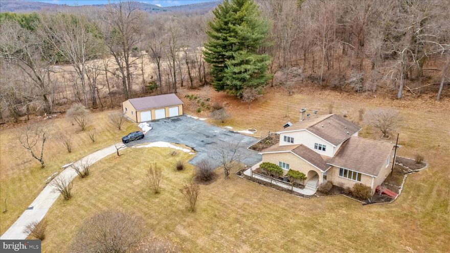 If privacy, character, and room to breathe are at the top of your list, this rare 4.27-acre retreat delivers. Tucked away from the hustle, this one-of-a-kind home offers the kind of setting you simply can’t recreate in a subdivision.  Designed with a distinctive layout full of personality, this home is anything but cookie-cutter. Solidly built with great bones, it’s ready for your vision—whether you embrace its retro charm or transform it into your dream modern escape. Warm and inviting, the family room features a striking floor-to-ceiling stone wall with a cozy wood stove—perfect for quiet evenings at home. On the opposite side, a spacious great room offers endless possibilities for entertaining, relaxing, or creating the ultimate gathering space. An additional flex room makes an ideal private office, studio, or hobby room. The kitchen, with table space, connects seamlessly to both the living and family rooms, creating a natural flow for everyday living. Upstairs, the owner’s suite includes a private bath and peaceful views of the surrounding property, while three additional bedrooms and a second full bath provide comfortable space for guests.  
The unfinished lower level is a blank canvas—home gym, workshop, recreation room—you decide.
Outdoor living shines here, with a welcoming front porch, a relaxing back patio, a detached 3-car garage, and expansive acreage offering privacy, nature, and endless possibilities. No HOA and no city taxes mean more freedom to truly make it your own.  Freshly painted throughout.  Recent water heater (2024). Estate/Trustee Sale – sold as-is. Inspections for informational purposes only. Located in the Myersville/Middletown school district.  A rare opportunity to own a private property with character, space, and unlimited potential.