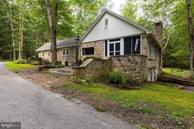 Nestled in the serene setting of Caledonia State Park, this unique stone rancher offers a rare blend of rustic charm with modern updates. With 4 spacious bedrooms and 3 full bathrooms this home is perfect for those seeking comfort and character in a peaceful, natural environment. The property showcases thoughtful updates throughout including quartz flooring in the primary bedroom that adds a touch of elegance. Large windows throughout the home invite in natural light and frame breathtaking views. Whether your relaxing by the stone fireplace, enjoying the surrounding woodlands, or playing a round of golf, this home offers a lifestyle that is both inviting and one-of-a-kind. The finished walkout basement also provides versatile living space—ideal for entertaining, guest quarters, or a home office with direct access to the outdoors. Experience the tranquility of park living with easy access to trails, nature and more-don't miss your chance to own a truly special retreat.