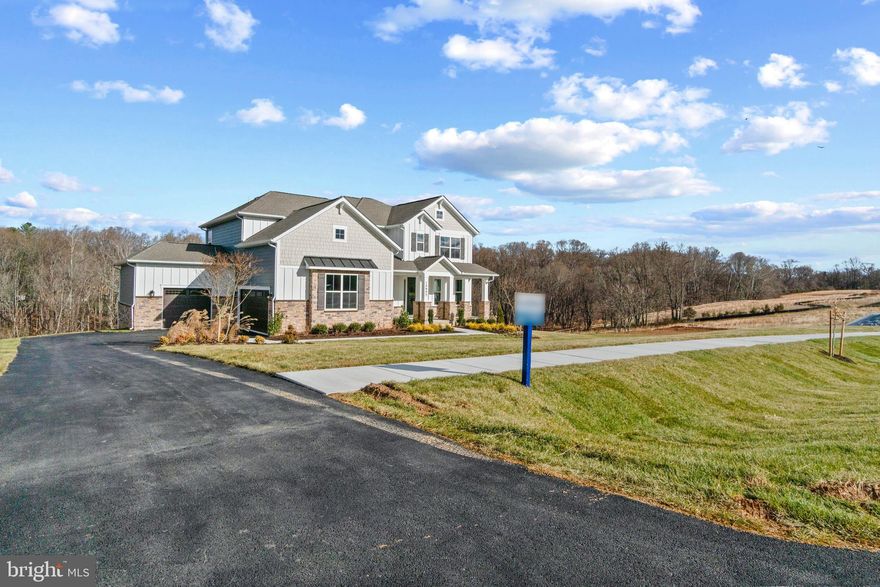 Immediate move in available! New home for the new year! Country meets luxury living on this sprawling 1.4 acre, 5 bed 4.5 bath home that backs to conservation area. The "Vanderbilt" features a 1st floor primary bedroom suite with tray ceilings, and a spa inspired bathroom with dual vanity, frameless shower, separate garden tub, and oversized walk-in closet. The primary bedroom leads out to a back covered porch with a breezeway to the kitchen. The chef's kitchen features quartz waterfall countertops, cooktop, stainless steel built-in microwave oven, soft close cabinets, optimal pantry storage, and dedicated casual dining area. The 2-story foyer opens to a flex space that is usable as a home office or formal dining. Laundry room located off the 3-car side load garage. The 2-story living room features a total of 8 windows facing the private backyard space, giving optimal opportunity for natural light. The oak staircase walks up to the loft with engineered wood floors throughout all the hallways; 3 bedrooms and 2 full baths (one en-suite), complete the second floor. Basement includes a finished rec room, bedroom and full bathroom. Price listed is for final, complete home. January closing available. Ask about our financing incentives! 
 *Photos not of actual home, and are of a similar model*