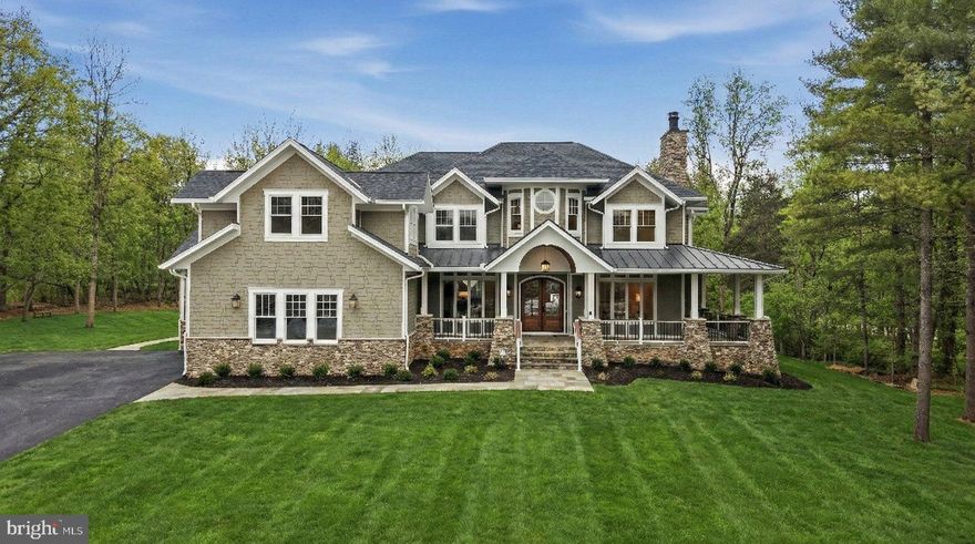 Set on just over 10 private wooded acres, this exceptional new construction estate at 22597 Red Hill Manor delivers a rare blend of architectural detail, refined craftsmanship, and flexible living spaces designed for modern luxury and multi-generational living. The residence offers five bedrooms, six full bathrooms and two half bathrooms, and features five fireplaces thoughtfully placed throughout the home, including the great room, living room, hearth/keeping room, primary suite, and lower level living areas.

The main level is defined by soaring ceilings, wide-plank hardwood sand in place flooring, and extensive custom millwork, creating a seamless flow between formal and informal spaces. The kitchen is a true centerpiece, with a massive center island and outfitted with a premium Sub-Zero, Wolf, and Cove appliance package, including professional-grade cooking, built-in refrigeration, wall oven, microwave, and paneled dishwashers. A fully equipped scullery and walk-in pantry extend the kitchen’s functionality with additional refrigeration, beverage storage, and prep space, while a dedicated coffee bar and butler’s area elevate everyday convenience. A private main-level office with its own exterior entrance and custom cabinetry and wet bar offers outstanding flexibility for professional use or a quiet retreat.  The main level is equipped with a massive laundry area with plenty of custom cabinetry and counter space.  An additional laundry room is located on the second level for convenience.

The upper level features generously sized secondary bedrooms, all finished with curated tile selections, custom cabinetry, and designer fixtures. The primary suite serves as a private sanctuary, highlighted by a sitting area, gas fireplace, spa-inspired bath with soaking tub and oversized walk-in shower, and a custom tailored closet.

The lower level is designed as a true extension of the living space, offering a large recreation and family room, wet bar, wine cellar, and multiple specialty areas. A large bedroom or recreation suite with a full bath provides ideal accommodations for guests or multi-generational living. Wellness features include a sauna and steam shower and an additional full spa bathroom with a steam shower and double vanities, while additional fireplaces and walk-out access enhance comfort and usability.

Outdoor living is equally impressive, featuring a large Trex deck with Trex railing system and a stamped concrete patio, creating multiple spaces for entertaining and relaxation. The exterior architecture is distinguished by extensive custom stonework, including stone façade elements, flagstone walkways, and thoughtfully designed hardscaping that complements the natural setting. The home is clad in HardiePlank siding with multiple textures, adding depth, durability, and visual interest to the exterior design. A three-car garage includes a custom dog wash station, combining practicality with thoughtful luxury.

Throughout the home, carefully selected finishes and materials reflect a cohesive design vision, including custom cabinetry, quartz and quartzite countertops, designer lighting, specialty tile installations, and detailed trim work.