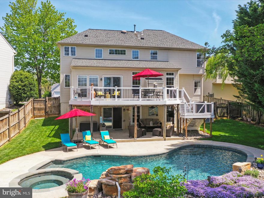 Welcome to this stunning Colonial-style home, a perfect blend of elegance and comfort, nestled in a serene neighborhood. Spanning 4,085 sq. ft. , this residence boasts 4 spacious bedrooms and 3.5 luxurious bathrooms, including a primary suite with a jetted tub and walk-in shower. The heart of the home features an open floor plan with a family room off the kitchen, ideal for gatherings. The kitchen is a chef's dream, equipped with stainless steel appliances, a gas range, and an island for additional prep space. Step outside to discover a beautifully landscaped yard with extensive hardscaping, a personal heated pool, and a deck perfect for entertaining. The property backs onto open common areas, providing a sense of privacy and tranquility. Additional highlights include a fully finished basement with a  bar, a pellet stove and ample storage options. With an attached garage and driveway parking, convenience is at your fingertips. This home is not just a place to live; it's a lifestyle waiting to be embraced. Don’t miss your chance to make it yours!