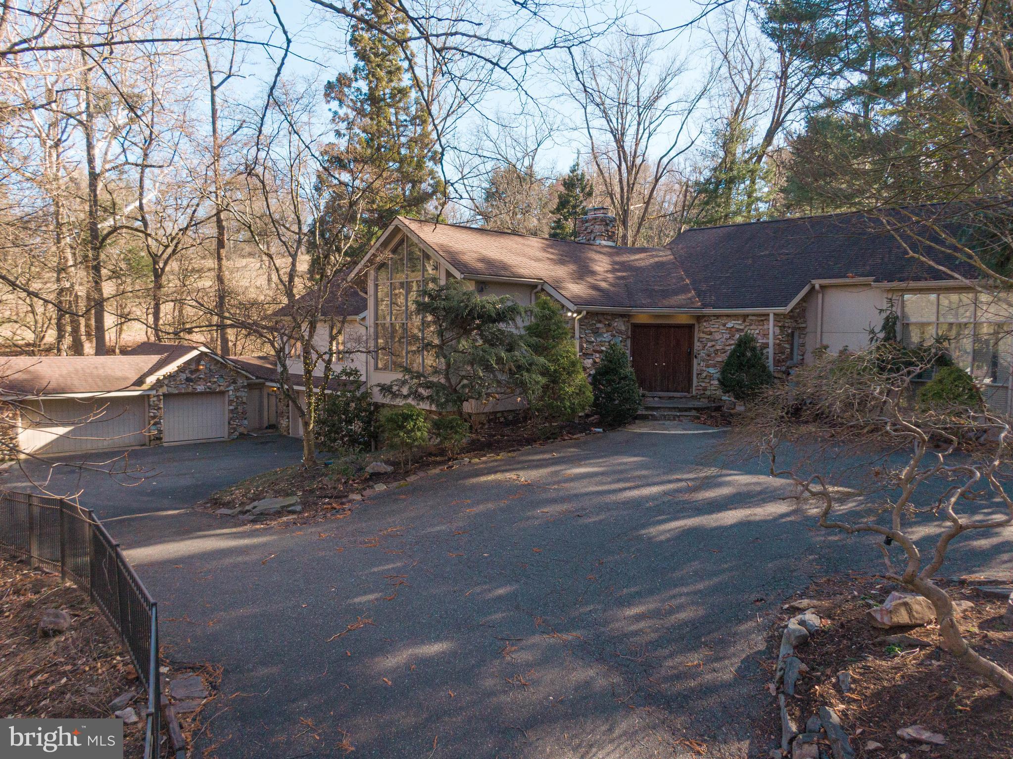 A secluded contemporary designed by Perc Kennedy. This 5 Bed, 5 1/2 Bath 5,000+ sq ft home sits on a 2 acre parcel overlooking a beautiful meadow and stream. Features a pool, tennis and basketball court along w lush landscaping and 6-8 car garage parking in addition to driveway parking. Gorgeous foyer entry welcomes you into this delightful, one of a kind home. Library via statement piece accordion door, living and bonus room. Oversized windows throughout providing full views of outdoor greenscapes which are breathtaking all year round. Separate dining room and bar, chef's kitchen includes double oven and double sinks. First floor primary bedroom suite, solarium which could be used as a workout room and/or greenhouse along w walk in closets and an additional bedroom w a faux fireplace and another walk in closet. 2nd floor hosts 3 additional bedrooms each with full baths. Gorgeous pool and exterior pathway which leads up to the tennis-basketball courts. This special home provides serenity, privacy and convenience to train and shops situated in top rated Lower Merion School District.