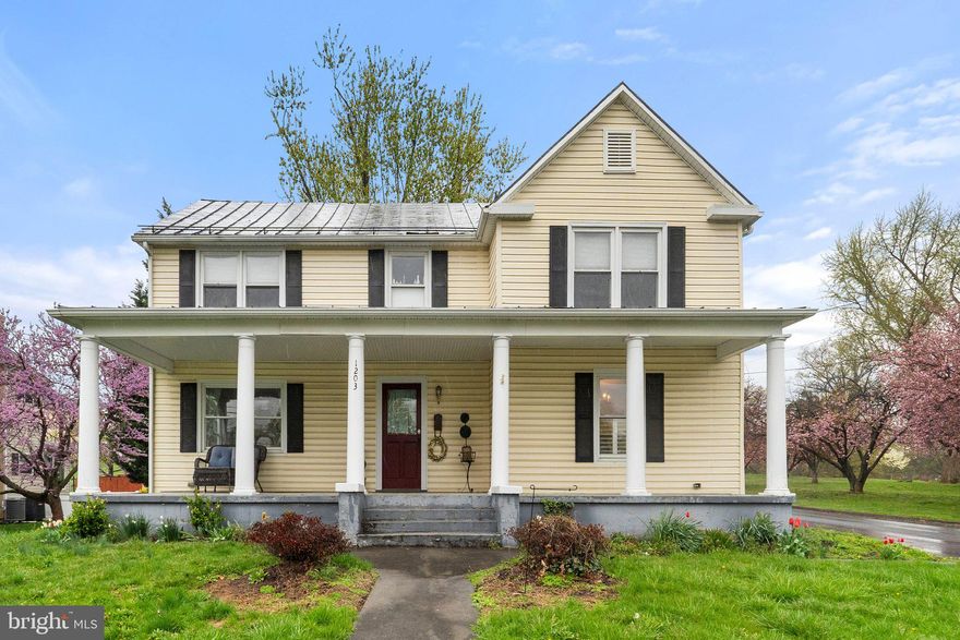 This cozy, 1920s farmhouse sits on a spacious corner lot a few blocks from Old Town. The sunny yellow façade pairs with an inviting covered porch spanning the front of the home—the ideal place for rocking chairs and other furniture. Inside, warm hues combine with real hardwood floors, plus custom trim details like classic, three-piece baseboard and custom stairway newel posts to bring out the charm. A grand foyer
segues to the living room, where a wood-burning fireplace brings added warmth. The kitchen includes banks of white cabinets in a traditional U-shape with ample counterspace to prep and cook. Easily add a butcher block, island, or informal dining furniture. The adjacent dining room also provides generous space for tables, chairs, and your display cabinets or buffets. A convenient half-bath is also located on this level.
Upstairs splits the bedrooms. One direction takes you to the primary suite, which includes a walk-through closet and attached full bath with heated floors. The other direction takes you to two bedrooms, a full bath, and the laundry room. A grassy yard with flowerbeds surrounds the home, and a beautiful, mature tree is a standout in the fenced backyard. This older charmer has benefited from upgrades through the years, and you can’t top the location, sitting in a beautiful Winchester neighborhood near Handley High.