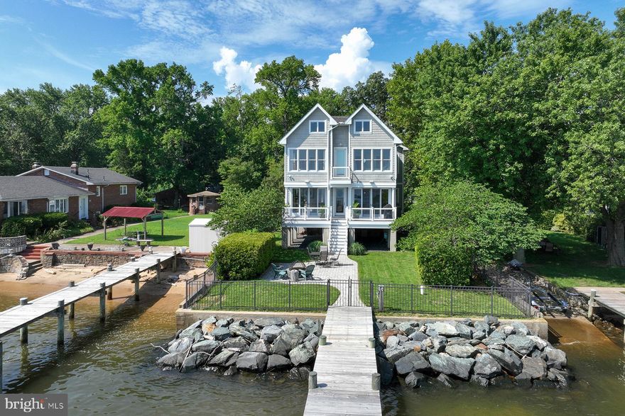 Welcome to your dream waterfront retreat! 2022 Kurtz Avenue is located in Paradise Beach, nestled on the shores of the Chesapeake Bay. This stunning home offers a harmonious blend of coastal-inspired elegance, spectacular Bay views, and a sense of tranquility with a never-ending horizon. The property boasts a variety of options to enjoy the views and embrace the beauty of the natural surroundings. From the waterside decks to the inviting paver patio, every inch of outdoor space is designed for relaxation and entertainment with a view. Boaters and water enthusiasts will appreciate the thoughtfully constructed large pier complex, which offers seating areas and a convenient boat lift.

As you approach the entrance, you'll be greeted by a charming covered porch that is accented with a standing seam roof and crafted with low-maintenance materials. Step inside and enjoy the ever-changing panoramic views of the Bay that fill the entire home with an enchanting light. The foyer leads to the great room, with Boardwalk Series porcelain tile floors and expansive hurricane-rated Anderson windows & sliding glass doors. The seating area can take advantage of the gas fireplace in the colder months, while the dining area has those glorious water views for every meal. Step out to the waterside deck for an alfresco meal or BBQ and enjoy the Bay breezes. The gourmet kitchen features custom maple cabinets, a stunning glass tile backsplash, and granite countertops. The kitchen island boasts a gas stove and a dual-temp wine fridge, perfect for culinary enthusiasts and entertainers. And the walk-in pantry provides ample storage for all your needs. Down the hall, you can experience an incredible theater-like experience with integrated 100" 4k projection system and Dolby Atmos surround system. There is a powder room, so the theater room could also serve as an additional bedroom. There's flexibility in the living spaces on each level.

Upstairs, the primary bedroom suite provides incredible water views. Imagine waking up to a breathtaking sunrise each morning. This oasis includes an ensuite bath with a dual-sink vanity, an oversized shower, and a soaking tub for the ultimate relaxation. A walk-in closet and a waterside observation balcony complete this luxurious retreat. Adjacent to the primary bedroom, there’s a lovely waterside bedroom, perfect for accommodating family or friends. The spacious third bedroom has more than enough space for an office and an exercise room. Convenience and comfort define this level, including a large hall bathroom and a laundry area. On the top level of the home you'll discover a fantastic bonus space. This space is perfect for hosting overflow guests, creating a playroom, or keeping a private office space with a mesmerizing view of the water.

It's worth mentioning that this home was designed with a commercial grade cement piling foundation that showcases the commitment to quality and longevity of this well constructed home. There is a fully fenced yard on the waterside, and the rip-rap on the shoreline gives added protection during storms. It’s an easy commute to Baltimore, Annapolis, or DC. By car, you're just minutes away from restaurants, golf courses, and shopping. And if you prefer to explore by boat, there are many destinations to find from waterside restaurants to quiet anchorages.

This remarkable property combines the allure of a luxurious coastal getaway with the convenience of modern amenities, making it a haven you'll never want to leave. Don't miss the opportunity to make this waterfront retreat your own and experience a truly extraordinary lifestyle on the Chesapeake Bay.