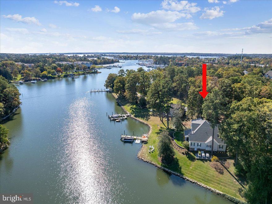 LUXURY WATERFRONT LIFESTYLE.  Enjoy this 4311 SF refined coastal home on Back Creek. The creek views are prominent throughout  the residence, and provide a tranquil backdrop. The property itself is one of four very special and private waterfront sites within this gated community, and is located just a short walk, bike ride or boat ride to Solomons Island...its restaurants and bars, yacht club and marinas. The outdoor living is completely focused on the creek with 280 ft of shoreline, private pier with 5 ft deep water, floating AccuDock launch. The interior floor plan is perfect.  Enjoy meals and relaxation on the large screened porch and patio areas, located just off of the kitchen and family room areas. MAIN LEVEL LIVING. Exciting interior features include dramatic ceiling heights custom wet bar in the living room. The wet bar was a 2024 customization. The main level primary suite is creek-side with vaulted ceilings, a very spacious private bath with oversized shower and fully outfitted owner's closet and direct access to the screened porch. This bath was renovated in 2024. A cheerful corner sunroom captures both morning and afternoon sun. This room is perfect for reading,  special conversations, complete with Mecho motorized blinds. The gourmet kitchen is beautifully arranged for the chef, with custom cabinetry, higher-end appliances and great work space, and access to the breakfast nook and the dining room are immediate from this kitchen plan. There is a main level media room that is a flexible part of the floor plan. Perhaps a home office is important? UPPER LEVEL PLAN. You cannot miss the incredible water views from the upper level landing and walkway, leading to three gracious bedrooms and a large hobby-storage space. Bedroom 2, used by the owners as a bunk room, has a private bathroom. Bedroom 3 is currently a home gym, with removable rubber matt flooring and more stunning creek views. The built-in TV conveys. Bedroom 4 is a wonderful corner suite with fabulous creek views, pocket door makes en suite plan with bath 4.. EXTRA ROOMS. The garage is 24 x 22, with built-in shelving and an established work station. This leads to the mud room with built-ins, complete laundry center with sink. The lower level is perfect for extra storage and service of mechanicals. READY FOR SUMMER! Bring your best expectations and this property will rise to the occasion. Live the special coastal life!