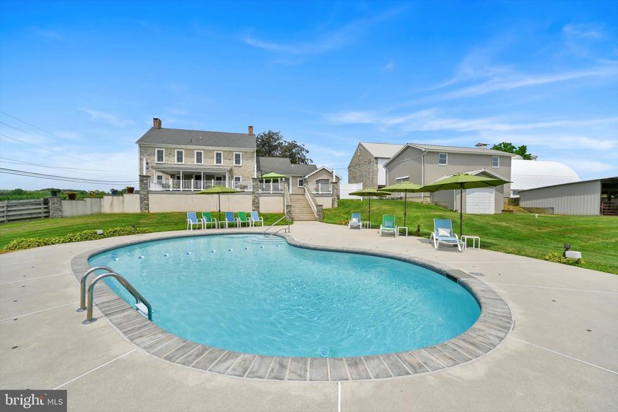 Step into timeless elegance at this masterfully restored 1830 Pennsylvania Dutch Farmhouse
nestled on 13 pristine acres. This 6-bedroom, 3.5-bath historic estate has very recently been fully
renovated down to the studs using reclaimed materials from the original property and local stone
— blending heritage with luxury country living.
The entry of the home not only welcomes guests — it tells a story of tradition, refinement, and
enduring charm. Thru the solid wood doors, tile flooring underfoot, detailed millwork, and high
ceilings offer a blend of timeless craftsmanship and understated elegance. To your left, a hall that
leads to a half bath , lunch nook and entryway to the backyard oasis. Lined with built-in custom
cabinetry, a commercial size refrigerator and full laundry creates the amazing butlers pantry.
The chef's kitchen is the centerpiece, showcasing custom cherry cabinetry, soapstone
countertops, a Viking 6-burner gas range, and a one-of-a-kind wood-fired oven that is often used
for the most fabulous home cooked meals.
Anchored by warm hardwood floors and framed with deep-sill windows, the expansive dining
room is designed to be both inviting and functional. Perfectly positioned between the kitchen and
living areas, it features an open-concept layout that encourages effortless flow — ideal for
everyday family meals or entertaining guests. Natural light fills the space, while the windows
offer scenic views of the pool and horse pastures, creating a picturesque backdrop to every
meal.
Bathed in natural light and warmed by rich hardwood floors, the formal living room on the main
floor is a cozy yet elegant retreat. Oversized windows frame postcard-perfect views of the
surrounding hay fields. At the center of the room, a gas fireplace with brick surround adds
warmth and charm, complemented by handcrafted wood beam supports that honor the home’s
historic architecture.
When your guests get a little too cozy, a thoughtfully designed main-floor guest or in-law suite
offers a private bedroom and full bathroom, ideal for multi-generational living.
At the heart of the home lies the breathtaking Great Room , a true showcase of traditional
Germanic peg-built craftsmanship. Soaring vaulted ceilings and exposed wood beams create
an open, cathedral-like atmosphere, while the rich knotty pine finishes bring warmth and rustic
elegance. A striking floor-to-ceiling stone fireplace with a wood burning stove not only
anchors the space with historic character, but also provides radiant heat that rises to warm the
second floor. Bathed in natural light from all sides, this room is both a gathering space and a
sanctuary — ideal for cozy evenings by the fire or entertaining under the glow of its timberframed beauty. The charming home office featuring custom cabinetry and desk crafted from
trees on the property, set against authentic stone walls and wood beams.
The second floor features a spacious primary suite with a walk-in closet and a luxurious en-suite
bath, complete with a full-body Jacuzzi shower. Two additional bedrooms each offer generous
closets and picturesque views of the surrounding pastures from every deep-set window. A full
bath with double vanity and tub/shower combo, along with a discreetly tucked-away laundry
area, completes this level.
Surprisingly, the third floor opens up to two oversized bonus rooms—ideal for bedrooms, hobby
spaces, or guest quarters—each room showcases original wood overhead beams and gleaming
hardwood floors.
Step out onto the expansive back deck and take in panoramic views of the heated pool, charming
pool house, and sweeping horse pastures beyond. A lighted stone staircase gracefully descends
from the deck to the pool area, creating an inviting and elegant transition for both daytime
enjoyment and evening entertaining.
REMARKS CONTINUED BELOW :