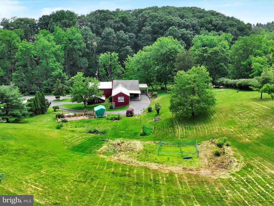 Discover a truly special opportunity to embrace country living at its finest! Nestled on over an acre of lush, picturesque land adorned with vibrant flowers, flourishing grapevines, and fruit trees, this charming 5 bedroom home offers a lifestyle many only dream of. Imagine entering through a welcoming covered porch overlooking a pond into a spacious, open kitchen and dining area—perfect for gathering with loved ones. The sunlit living and dining rooms provide serene views of a neighboring pond, a natural haven that attracts an array of wildlife, creating your own peaceful sanctuary. A generous 12x18 family room on the main floor offers even more space for relaxation or entertaining. The home features two full baths and three main-floor bedrooms, plus two versatile upstairs rooms that have served as bedrooms, offices or storage. A large first-floor laundry/mudroom with exterior access adds convenience to daily living. Outside, an attached 16x18 block building provides endless potential—ideal for a workshop, potting shed, studio, or extra storage. Opportunities like this are rare—don’t miss your chance to make this beautiful slice of the countryside your very own!