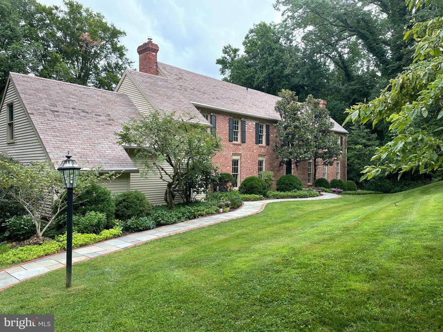 If you have been waiting for the opportunity to buy a home in the Shand Tract neighborhood of Tredyffrin Township, well today is your lucky day. If you haven’t heard about the Shand Tract neighborhood, I will tell you a little bit about the neighborhood. This neighborhood was developed in the 50’s and 60’s by Alexander Shand. With his civil engineering education, he laid out attractive street designs which fit the natural environment and preserved elegant old trees. The homes vary in lot size and square footage. It is a close-knit community that has welcoming neighbors eager to help with recommendations for sitters, snow removal, handy people and even has an annual progressive dinner and children holiday activities. Tredyffrin Township is known for its excellent private and public schools, Jenkins Arboretum, many recreational parks and a library. As you wind through the streets of the popular Shand Tract neighborhood, you will come upon a lovely, Georgian Colonial style, brick home flanked by two beautiful magnolia trees. Situated on a ¾ acre lot with a large back lawn, bordered by a babbling brook, this 5,000 square foot home is a perfect spot for you to call “home”. Entering into the home you will be impressed with the rich, hardwood floors. Walking to the right is the formal dining room with an expansive view of the backyard. There are dental moldings and a built-in arched cabinet. The dining room leads to the remodeled kitchen with built in banquet seating, pretty custom glass and solid cabinetry, granite counters, a wet bar area, two dishwashers and a wonderful view of the backyard. There is also a very convenient "dumb waiter" that runs from the kitchen (under cover) to the  patio area, making  dinner service to the patio a snap. To the right of the dining room is a lower-level formal living room. The living room has the same expansive view out the back, a wood fireplace with a gorgeous mantel, and doors to a private patio area. This patio area is a perfect spot to enjoy a quiet moment sipping coffee or reading your favorite book. On the other side of the kitchen is a warm, family room with a wood burning fireplace and more views of the great outdoors. Going back to the front entrance you climb a formal staircase leading to the second floor. The second floor has some carpeting covering the hardwood floors. On this level there is a primary suite with en suite bath and four additional bedrooms, two full baths and a laundry.  From the fifth bedroom there is a back staircase. At the bottom of the staircase is the egress to the two-car garage. The lower level has a large carpeted entertainment room with a wet bar and French doors leading to a perennial garden and landscaped terrace. There are two additional rooms on the lower level that could be used as a guest room, exercise or storage room and a full bath. As if there were not already tons of storage in this home, there are  pull down stairs (new) to the standup attic the length of the second floor. The backyard is perfect for all kinds of sports. The nature provides a tranquil setting with many species of birds and plants. Don’t miss out on this opportunity to live in the popular Shand Tract neighborhood. You will love it!