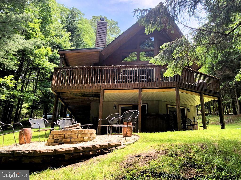 Set on 1.26 wooded acres in Sky Valley, this classic Lake Access chalet blends privacy with access to some of Deep Creek’s best amenities! Vaulted ceilings and timber frame accents open up the main living area - full of natural light. The kitchen features updated appliances and sits just off the main gathering space. A wraparound deck and covered porch offer plenty of space to relax outdoors. Downstairs includes a spacious family room with a pool table, wet bar, and walk-out access to a hot tub tucked under the deck. Two fireplaces. Private fire pit patio. Primary suite includes its own balcony. Lake access includes a sandy beach, community boat launch, and eligibility for a dock slip through the HOA waiting list! Clean layout. Solid structure. A peaceful mountain retreat. Call today for details!