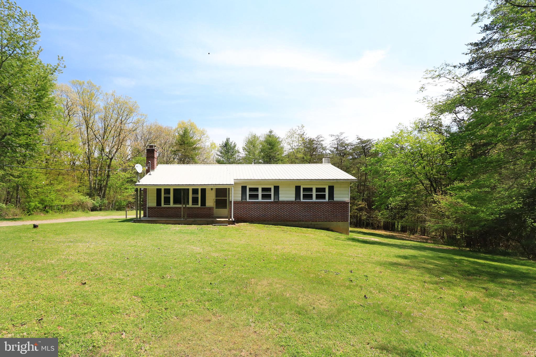 Rare opportunity to own a one level home on five+ private acres bordering Rothrock State Forest. Nature surrounds you in this peaceful, country setting. Priced to sell, here's your chance to put your remodeling touches on this solidly built home and make it just the way you want it. The sizable living room features a stone wood-burning fireplace and a large picture window. There's ample room in the kitchen and space for more cabinets or an island. The primary bedroom is a good size and features a half bath. Opportunity abounds in the unfinished walk-out basement which comes with a wood stove and a workbench. A front porch, a shed, and a metal roof are additional features. A short drive to Whipple Dam means you're close to fishing, boating, and spending a day at the beach. Located about twenty minutes to State College you'll love the proximity to town and campus while having the almost 100,000 acres of Rothrock State Forest near your doorstep.