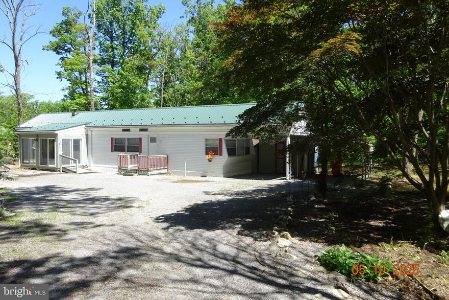 great private setting enjoy nature and beauty of the outdoors in this update mobile home located on 2 acres, features 2 bedrooms,2 bathrooms, one which is totally remodeled handicaped access. kitchen has been all updated with ceramic tile floor,carpet living room, rear sunroom addition ,plus front enclosed porch which can be used as breakfast nook area.  100 amps  service, public sewer, water system is a cistern tank. fish pond in front yard, 3 storage sheds, circular driveway, updated metal roof  2020 . shippensburg school district, acreage is on 2 lots live in  mobile  and build   your custom built home, in back on  wooded lot.  This is a great location for peace and quiet . A must see property .priced to sell. no permanent foundation .unit  has tie downs.