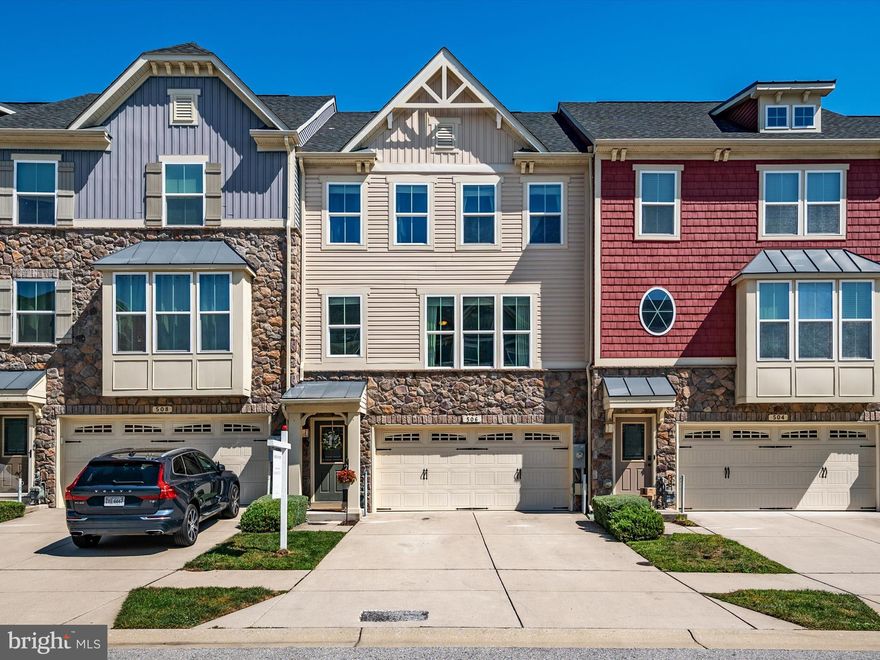 Welcome home to this stunning two-car garage townhome in the sought-after Creekside Village community! Built in 2015, this home shows like a model and features 3 bedrooms, 2.5 bathrooms, and over 2,100 square ft of living space with a premium lot backing to trees! The main level boasts gorgeous hardwood flooring throughout, complemented by large front windows that flood the space with natural light. The spacious living room, highlighted by a beautiful accent wall, flows effortlessly into the gourmet kitchen. The kitchen is a chef's delight, offering 42" cabinetry, modern subway tile backsplash, stainless steel appliances, must-have pantry, a large center island, and a convenient bar/coffee nook. From the dining room, step out onto your expansive composite deck, which offers serene views of the wooded area—perfect for evening relaxation! Head upstairs and unwind in the luxurious primary suite, complete with tray ceilings, a large walk-in closet, and an en-suite bathroom featuring dual vanities, a large soaking tub, and a separate shower w/built in seat! Two additional bedrooms, a full bath, and convenient laundry room complete this level! The lower level provides even more space for entertaining, serving as a versatile guest suite, additional living space, or playroom. Creekside Village offers FANTASTIC community amenities, including a pool, gym, dog park, playgrounds, walking/jogging trails, basketball court, clubhouse, & lawn care! Located in an ideal location for commuters, this home is centrally located and less than 30 minutes away from Fort Meade, Baltimore, and Annapolis! Come see this beautiful home today! VA ASSUMABLE LOAN for eligible buyers! OPEN HOUSE  SATURDAY 9/14 12-2PM and SUNDAY 9/15 1-3 PM!