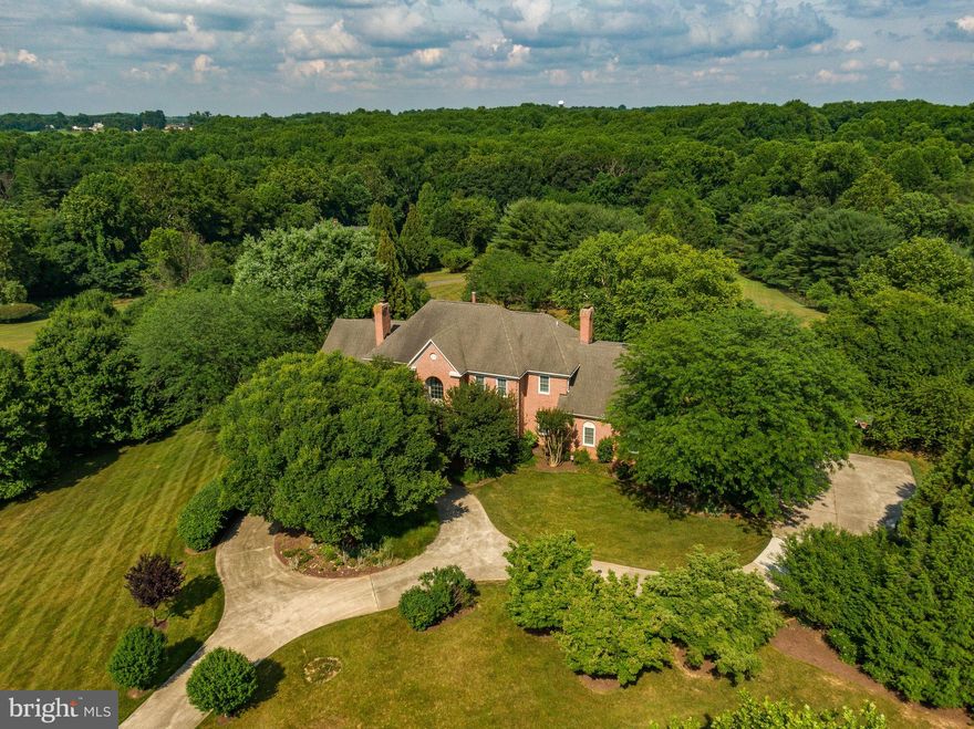 Fulton, Maryland is a hidden oasis conveniently nestled between everywhere you want to be in the DMV. While enjoying 3 acres in a beautiful & quiet neighborhood, your home is less than 23 miles from downtown DC or downtown Baltimore. This expansive 3-level estate features 6 bedrooms, 6 ½ bathrooms and over 9000 SF of interior living space. The maintenance-free Trex deck runs along the house's entire back, offering 700 SF of elevated outside enjoyment. Plenty of space to spread out in serene solitude and close convenience to all DC-area amenities. 2-Story Entrance with curved stairway welcomes you. The Sitting Room features a stunning fireplace & half-wall wains-coating that oozes stately elegance. The adjoining formal Dining Room, with French Doors opening to the Sunroom, has plenty of space for conversation/a great meal with family/friends. You'll enjoy traditional hardwood floors while the earthy Mexican tile in the Kitchen & Sunroom adds warmth & texture to the open concept. The glass-lined Sunroom, with 6 doors leading to the deck & 3 skylights, spans the home's length. Click on Self-Directed 3-D Tour!! You will fall in love with the Gourmet Kitchen! Tons of granite counter space for meal preparation and stainless-steel appliances include a six-burner JennAir cooktop, griddle, double ovens, side-by-side refrigerator, dishwasher, garbage disposal, microwave, and food warmer. Plenty of cabinets. A large walk-in pantry adds phenomenal storage with a 2nd refrigerator. The high ceilings throughout this home with recessed lighting at all the right places and ceiling fans everywhere you'd want them providing an air of comfort & elegance to every room. On the main level is the in-law suite with a private entrance. This oasis has a separate Kitchen, Living Room, Bedroom, and full Bath with a walk-in shower & granite topped vanity. Great separate living area for au pair, or as a separate apartment. As the owner, you'll enter via the spacious 3-Car Garage, already outfitted with abundant built-in shelving. Freshen up in the perfectly-located Bathroom as you come in. The combination of high-end finishes & the beautiful stone fireplace makes the Family Room cozy and elegant. Walk out and enjoy the views and country quiet as you relax on your beautiful deck. On the upper level is the Primary Bedroom wing with a large sitting room featuring cedar-lined closets, a massive sunlit bedroom and a luxury bathroom suite. The custom tile work is as stunning as it is inviting. The Lower Finished Level spans the home's footprint. In this massive space, there is a huge Great Room, 3 additional Finished Rooms for whatever you'd like to use them for, Work-Out Room, Kitchenette & Full Bathroom! Storage space and closets galore. The Deck steps lead to the expansive backyard, a great place for kids/family/friends to play games. Pull up a few chairs to the firepit to hang out & roast marshmallows on chilly Fall evenings. The circular driveway is a stylish welcome for guests & the side entry garage enhances the home's luxurious exterior. Close to commuting routes 29, 32, and 95 & minutes from Maple Lawn Town Center. Make this home yours today! Note: Amount of rooms with bedroom characteristics exceeds the rated amount for the septic permit that was filed with Howard County on 4/21/1989.