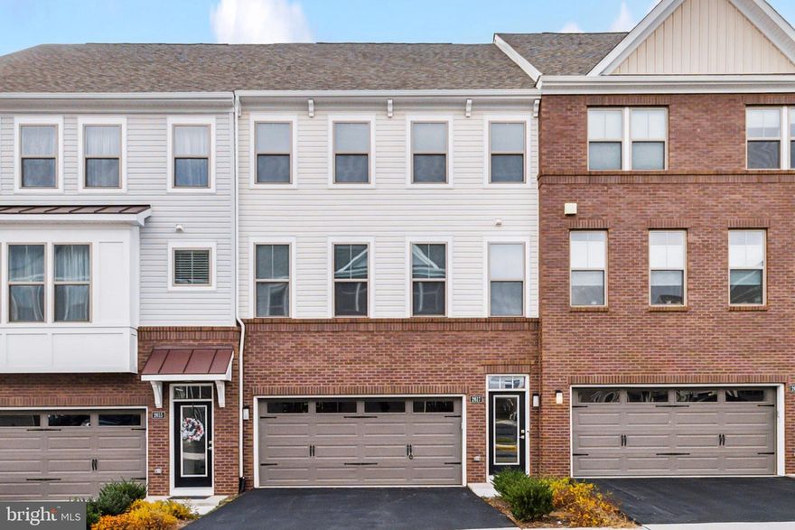 Welcome to Towns at Carters Grove! This nearly new townhouse boasts four bedrooms spread across three levels, all while backing onto a serene wooded conservation area. Constructed by Beazer in 2023, this home offers over 2600 square feet of living space, including a two-car garage with additional storage. Upon entering through the main glass front door, you're greeted by a spacious rec room on the first floor, featuring lofty ceilings exceeding 11 feet and glass doors opening to the backyard and conservation area. This level also includes a generously sized bedroom and private full bath, making it ideal for extended family members or an au pair suite. Ascending to the main level, you'll find an open floor plan with a sprawling gourmet kitchen equipped with a substantial center island, high-end stainless appliances, stone countertops, and double ovens. Adjacent to the kitchen, a versatile room can serve as a home office, additional dining area, or play space. Completing this level are the living room, dining room, and a half bath, with a Scion Trinity electric fireplace enhancing the ambiance in the living area. Moving to the top floor, the expansive Primary Suite awaits, complete with a luxurious full bath, oversized walk-in closet, and marvelous views of the conservation area. Two more bedrooms, each with walk-in closets, an additional full bath, and a laundry room round out this level, ensuring this townhome offers all the amenities one could desire. Its prime location near major transportation routes and a wealth of amenities, including Dulles International Airport and the Silver Line Metro, makes this property a truly luxurious find.