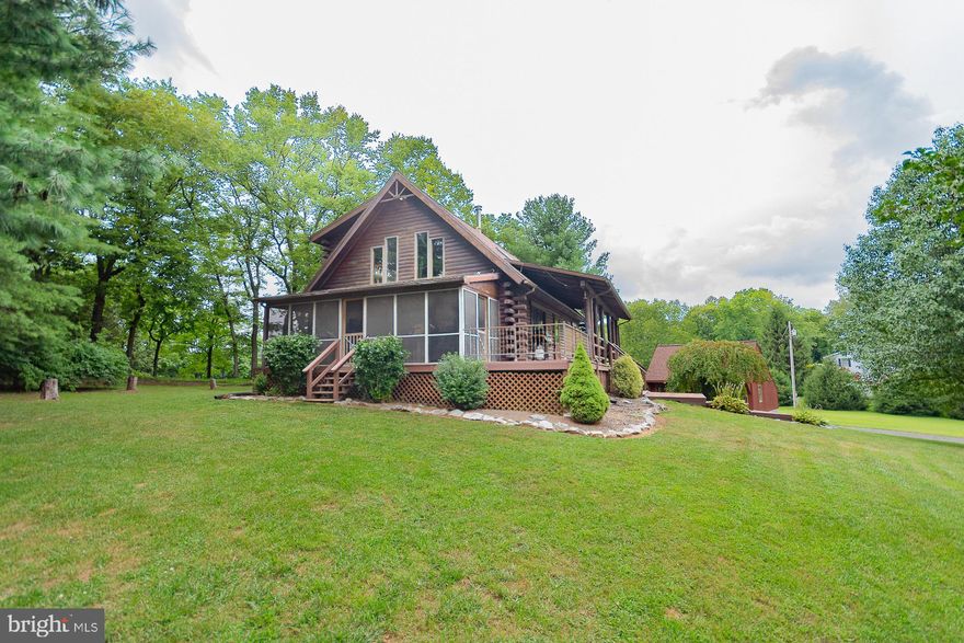 Back on the market at no fault of seller...Welcome to this custom log home on three acres, located near the Jefferson County line. Offering rustic charm with modern updates, this property features three bedrooms, two full bathrooms, a full unfinished basement, and an attached one-car garage.

The wraparound porch includes both open and screened-in sections, perfect for outdoor relaxation or entertaining. Inside, highlights include pine hardwood floors, hand-crafted wood doors, wood block accents, and a mezzanine overlook that enhances the open design of the living space.

A detached two-car garage provides additional storage and includes an upper level with potential for finishing as a studio, guest space, or workshop. Both the home and garage roofs were replaced in 2019 with a 50-year warranty. A recently installed HVAC system also includes a transferable warranty.

Additional features include an invisible fence with two collars and perimeter flags, plus a park-like setting with panoramic views of Jefferson and Berkeley Counties. 

Schedule your private showing today to experience all this property has to offer.