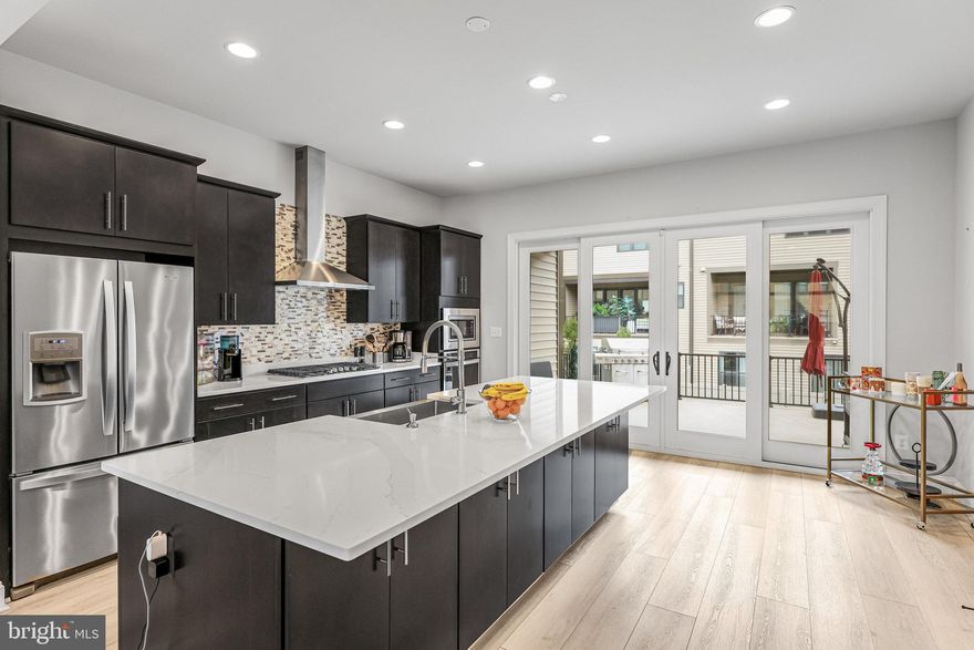 PRICE REDUCED!!! BETTER THAN NEW!!! This stunning open floor, 3 level townhome completed 2021, screams Modern Sophistication!!!...It offers the perfect blend of elegance and functional design. Located in the heart of Fairfax, this elegant home offers 3 bedrooms, 2  full bathrooms, and 2 half bathrooms. Almost 2400 square feet of luxury living space. The main level features an spacious gourmet kitchen with all stainless steel appliances, beautiful calacatta Verona Quartz countertops, Travertine backsplash and an X-large kitchen island. The open floor plan on the main level, is inviting and exudes modern living perfect for entertaining. The large window fills the space with natural light throughout. The living room features a custom built wall with a TV designated recessed area and an embedded fireplace, creating a focal point in the living room. Modern 8 inch wood flooring adds warmth and elegance to the main level. The convenience of a sizeable laundry room on bedroom level, makes laundry an easy task. The fully finished, walk-out Basement, has great flow of natural light, featuring a mudroom and access to a bathroom for your convenience. The 2 car garage can be accessed from the basement.
This  is a PREMIUM LOT, and has one of the largest driveways in the community. It is a rare opportunity to indulge in refined living in this Fairfax premier location!!!