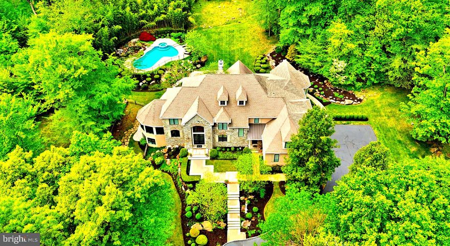 Be prepared to be impressed by this exquisite custom built home in Upper Makefield’s most prestigious location and premier neighborhood. Sited perfectly on over 5 acres with Jericho Mountain as the backdrop, this estate property was wonderfully crafted by Richard Zaveta in 2002, and further enhanced with an expansion in 2012 by Mack and Roedel, the two “Rolls Royce” builders in the area. This distinguished property features one of a kind architectural elements both inside and out, and is in immaculate mint, move-in condition. Standing majestically at the top of a 250 foot driveway, the home features one of the most stunning and dramatic Gourmet Kitchens and Primary Suites you will encounter in today’s market. The perfectly scaled and laid out rooms, expansive finished lower level, pristine pool, and manicured grounds make for a property precisely what you would expect in this highly sought after neighborhood of just 23 custom homes on larger lots, sprinkled throughout two cul-de-sacs. A dramatic two story foyer entry reveals a beautiful classic staircase with traditional white balusters, gleaming hardwoods, generous amounts of spectacular detailed millwork, ample natural light and a smart, comfortable floor plan. The main floor features an award winning kitchen with a 220” center island, multiple sinks and prep areas, highest end appliances such as Wolf oversized 6 burner double oven range, separate 36” Sub Zero refrigerator and freezer, Miele cappuccino machine, quartz counters, intricate box beamed ceiling, walk in pantry and more. Three sets of French doors open to the rear serene oasis featuring a huge patio, outdoor kitchen and in ground pool, all in a very quiet, tranquil, private setting. The adjoining family room boasts a double sided gas fireplace, shared with the dramatic two story living room, also featuring patio access. A cozy library retreat, large conservatory / office with walls of windows and cathedral ceiling, formal dining room with custom cabinets, large laundry room w/ outside access, and two powder rooms complete the main floor. The upper level has an extra wide hallway with overlook to the family room, convenient rear staircase, and is flanked by large bright and airy bedrooms (Bedroom 5 is currently used as a upstairs family room), all with huge closets, and ceiling fans. The incredible Primary Suite has a tray ceiling, giant sitting room with vaulted ceiling, his and hers walk-in closets and exquisite bath with walk in shower, free standing tub, heated floors, and private toilet closet. The walk-out finished lower level has spacious bedroom 6 and full bath w/ steam shower, entertainment area, workout area, kitchenette, craft room, and ample storage space. Other features of this magnificent home are a whole house generator, central vacuum, three car oversized garage, multi zone HVAC, security system, irrigation, and more. This premier community, with NO HOA, is just minutes from New Jersey bridges, New Hope, Newtown, Washington Crossing, I-295/95; 90 minutes to NYC and 45 minutes to Center City Philadelphia. Offered by the original owners, this is an enchanting opportunity to acquire a remarkable estate property in the heart of the Council Rock School District.