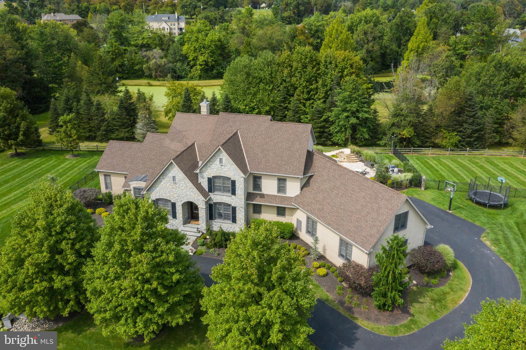 This custom built home by Trueblood Construction is located in one of the best neighborhoods in Buckingham. Minutes to Doylestown Boro which was voted USA Today's Best Small Town Cultural Scene in America! Peddler's Village and New Hope/Lambertville are also very close. You'll find plenty of Buck County things to do. Only 90 minutes to Manhattan and an hour from Philadelphia. Very spacious first floor owner's suite. There is another bedroom on the 1st floor which has its own full bathroom, making it perfect as an in-law suite. The gourmet kitchen features Wolf range top, Miele coffee machine, and Bosch wall ovens and is open to the family room with gas fireplace. Kitchen and family room have beautiful views of the pool and landscaping. Random width oak hardwood floors throughout the first level and most of the lower level are a timeless characteristic. On the upper level there are 3 bedrooms. One en suite bedroom and two others with a Jack and Jill bathroom. Large bonus room over the garage can serve many purposes. An open loft area can be another rec. room or home office area. On the lower level: Full, walk out to grade, finished basement with theater room, game room, full bar, wine/beer room, and living room areas and another full bathroom. The room that is currently the home gym would be a great home office , bright and airy with windows and glass doors. Amazing outdoor entertainment area featuring outdoor kitchen, fire pit, large pool with swim-up bar and hot tub, water slide and various smart phone controlled pool features. Other home features include: 4 zone HVAC. Whole house generator. Award Winning Central Bucks East High School.