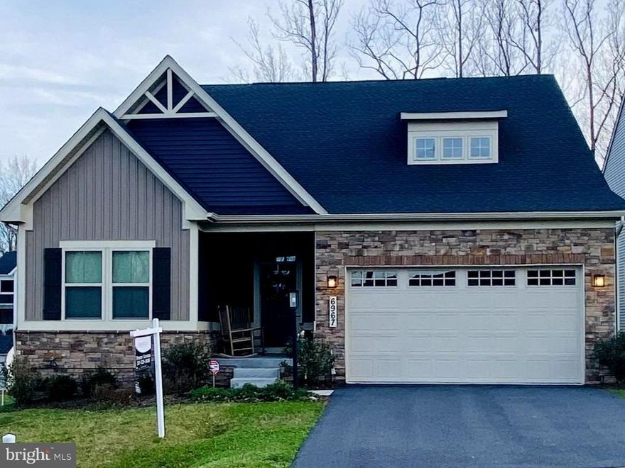 *First floor living with a wooded view *       This gorgeous 3 bedroom, 3 full bathroom, 2 car garage home on a premium lot in the newer Hamptons community in amenity rich Lake Linganore checks all the boxes for a lifestyle you'll love!  With over 1,600 square feet on the main level and over 2,600 Total finished sf, the Bramante ranch model offers a spacious sunlit open layout with primary bedroom on the main level.  From the covered front porch area, the foyer welcomes you in, and a convenient arrival center sits off the garage.  All on the first level you'll find the office/library with glass French doors, a large bedroom, plus the luxurious owner's suite which features a tray ceiling with a ceiling fan, an attached bathroom with a window, double bowl vanity, a walk-in shower with two showerheads on opposite walls, and walk-in closet for a spa-like feel.  A separate laundry room with upgraded front load washer/dryer is steps from the kitchen for your convenience.  Enjoy cooking and entertaining friends with the oversized quartz island in the gourmet kitchen that includes stainless appliances, a built-in microwave,  French door refrigerator, soft close cabinet drawers, a sparkling backsplash, dining area with a sliding door to access the covered porch with a maintenance free uncovered composite deck overlooking the flat backyard and   tranquil wooded views.   The adjoining family room has a gas fireplace to add a warmth and glow to your home, each window has motorized blinds operated with a remote control.  And that's just the main level!  Retreat downstairs to the huge finished walkout basement recreation room for even more living space and a very large unfinished storage room, think home gym, art studio, craft room!  Down the hall on the lower level you'll also find a generous sized third bedroom with walk in closet and a full bathroom. 
AND... This home was just built in 2023.  It has upgraded cabinets, a whole house humidifier, an efficient tankless water heater, LVP flooring, carpeted bedrooms, a navy kitchen island base with complementary white wall cabinetry that creates an impressive designer look and for your outdoor entertaining a permanent gas line for a BBQ on the lower level for a future outdoor kitchen.
Located in the desirable Hamptons community at Lake Linganore—swim, fish, boat! Enjoy the pools, lakes, beaches, trails, playgrounds, tennis, basketball, pickleball courts, community events and more.  
Minutes to commuter routes, I-70, and downtown Frederick.   6 miles to MARC Frederick train to DC.  Quick access to multiple grocery stores, shops and restaurants.