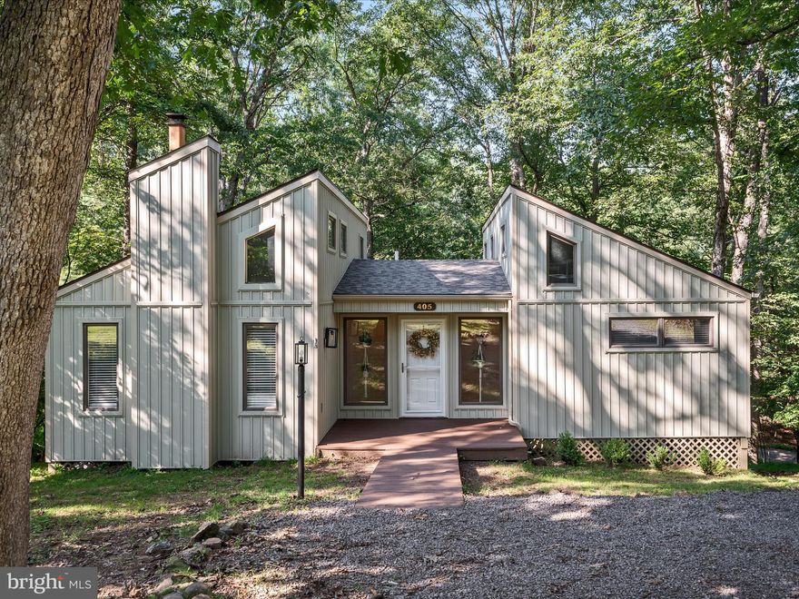 Move-in Ready Lake Holiday Retreat – Perfect as a Year-Round Residence or Vacation Getaway! Welcome to this beautifully remodeled contemporary home in sought-after Lake Holiday Estates! Nestled in a peaceful, amenity-filled community, this stunning property is ideal for both full-time living and weekend escapes. Step inside to discover a stylishly updated interior featuring gleaming hardwood floors and an upgraded kitchen complete with granite countertops, stainless steel appliances, and custom cabinetry. The living/dining room combo offers soaring ceilings with tons of windows for ample light, coupled with a newly installed oversized sliding glass door. The spacious primary bedroom has a newly installed door to deck, and the second bedroom includes a small loft, perfect for lounging or storage. The bathroom has been completely updated with heated tile flooring and a spa-like tiled tub/shower combo. The stackable washer and dryer is cleverly tucked behind a sliding barn door for added convenience. Enjoy year-round comfort with a new HVAC and energy-efficient heat pumps, while the brand new 30-year architectural shingle roof and beautifully updated siding offer peace of mind and curb appeal. One of the standout features is the detached screened-in porch, perched like a treehouse oasis — ideal for relaxing or entertaining. You'll also love the exterior-access lower-level storage, perfect for all your lake gear and tools. Come bring your boat and enjoy the many lake amenities this gated community offers: waterskiing and swimming, private beach access, fishing pier, playgrounds, various sports courts, fitness room, dog parks, and miles of walking and hiking trails!  Don't miss your chance to own this turn-key gem in a vibrant, recreational lake community.