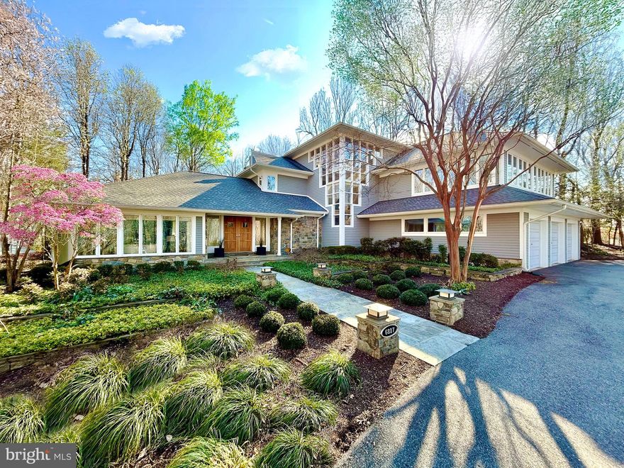 ***Special Open House, Sunday, April 27th, 2:30-4:30pm!*** featuring a classically trained flutist performing live and poolside for a magical home tour experience-

Exceptional modern design often walks a fine line between expansive openness and intimate livability. At 6817 Capri Place, this balance is achieved with remarkable precision. A study in light, form, and spatial relationships, the home seamlessly integrates grand, sun-drenched volumes with human-scale moments of warmth and retreat.

Nestled within the prestigious Palisades neighborhood of Bethesda, Maryland, this 8,700-square-foot residence sits on a breathtaking 1.5-acre lot. Designed to embrace its natural surroundings, the home boasts six bedrooms, five full baths, and one half-bath, each space thoughtfully positioned to enhance both privacy and connection.

The experience begins at the threshold, where an immediate sense of spatial clarity unfolds. Expansive glazing floods the interiors with natural light, framing dynamic views of the rolling landscape. Nowhere is this more pronounced than in the main living area—a soaring double-height space where walls of glass dissolve the boundary between interior and exterior. From here, sightlines extend seamlessly to the kitchen and a lofted mezzanine, a flexible space that functions as a lounge or, as the current owners have envisioned, a refined home office.

The rear elevation is a composition of shifting perspectives, continuously reframing the lush grounds and the striking pool. This interplay between built form and landscape is not merely aesthetic—it’s experiential. Each vantage point offers a distinct dialogue between architecture and nature, a testament to the home’s meticulous planning.

Perhaps the most iconic element is the staircase, a sculptural focal point that defines both the home’s facade and its interior experience. More than a means of circulation, it acts as a vertical light well, anchoring the residence while providing a rhythmic architectural counterpoint to the surrounding openness. Moving through this space is not simply passage—it is an event, a moment of engagement with the home’s design philosophy.

6817 Capri Place is not just a residence; it is a statement of modernist refinement, where architecture, landscape, and daily living converge in perfect harmony. This is contemporary luxury at its most intentional.