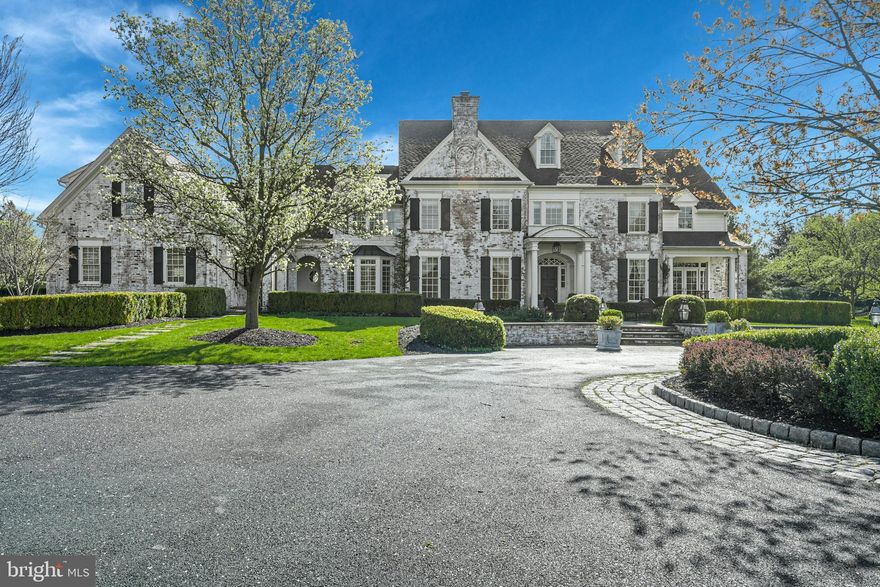 It is a rare pleasure to encounter a property such as Hawthorne, the very essence of elegance, evidenced at first approach, at the end of a drive with paver border and circular entrance.  Set amidst rich landscaping, on 4.6 park-like acres, the property fulfills and surpasses all expectations.  Lovingly built with an artistic eye and a reverence for classic design elements, this breathtaking home takes its character from English and American Georgian architecture.  These estates are defined by their grandeur and grace, with rooms of impressive proportions that flow effortlessly, one to another, with wonderful attention to detail, including custom woodworking and hardware, and boasting all the accoutrements that make for ease of living. They are rare now, but this gracious home is an example of the best. 
The timeless design features 10 foot ceilings and spacious rooms in more than 9,000 square feet of family living space on three floors.  Inside, each turn reveals delightful architectural details.  Fine materials and craftsmanship bespeak quality without compromise, while every element in design and execution is characterized by an understated elegance.  The large entry foyer is the heart of the home, offering a hallway running front to back, and a choice to enter the casual areas, or choose the more formal rooms, all flanking the main hall. 
Throughout, each room is bathed in light through oversized windows and interior and exterior transoms, skylights and multiple french doors to the private acreage beyond.  A handsome library features arched mahogany double doors at entry and French doors to a side porch.  The dining room, with fireplace, entertains large gatherings with ease. The exceptional gourmet kitchen was designed as the heart of the house, opening to the keeping room, family dining area and walls of windows affording views of the spectacular surroundings. Two butler pantry/wet bars are perfect for entertaining.  A large family office, back foyer, beadboard-appointed mudroom and a 2nd stairway are a great way to connect and enjoy family time.
The breathtaking central staircase arrives at a second floor landing, where, steps away, the primary bedroom suite boasts a sitting room, sumptuous bath and balcony.  Completing the rooms on this floor are 4 additional bedrooms, laundry room, study and a second floor family room with vaulted ceiling and custom built-ins.
Befitting the requirements of today’s family, without sacrificing luxury, there are rooms for every need or hobby, designed for large or small family gatherings.  The lower level invites guests and family to relax and enjoy the game room, bar and exercise area. A large, lower level storage area and an oversized 3 car garage will accommodate your family vehicles, sports equipment and bicycles for the rails to trails at street’s end.
Tucked away at the end of a cul-de-sac, this picturesque 4.6 acre property has carefully curated pine trees, boxwoods and flowering trees and gardens.  Patios, porches and intimate gathering areas have been thoughtfully arranged, amidst landscaping that has enjoyed the embellishment of time.  Perfect privacy may be difficult to find in today’s world, but Hawthorne may be as close to perfection as you will find.