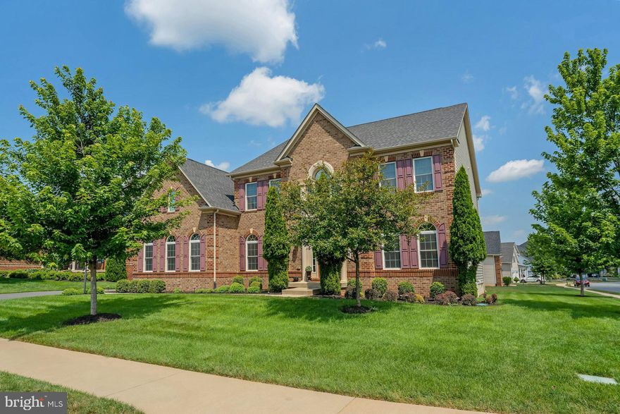 Prominent and enviable from its sunny corner-cul-de-sac setting, this graceful NV Homes haven welcomes within one of Ashburn’s most exclusive custom neighborhoods. Blending timeless architecture with modern sensibility, you’ll cross the threshold and unwind where a captivating staircase welcomes and an open floorplan of richly stained hardwoods, light-filled windows, bespoke moldings, and beautifully crafted ceilings soothe. While the airy double storied living room boasts stately built-ins for displaying memories and best-loved reads,  loved ones will adore the lofted hall for sneaking-in last goodnights and helping with holiday cheer.  Sophisticated with inky hues contrasted by a cloudlike pallet of stone, your alluring kitchen serves savory aromas and pours glasses of wines assisted by professional grade appliances and endless soft-close cabinetry. Here, prep weeknight meals and recipes for summer celebrations on the oversized deck - where firepit fun, restful weekends, and a four-legged friend enjoy .32 acres of landscaped green. At day’s end, five bedrooms and five baths are tranquil, including a main level full bath complementing an office/bedroom with walk-in closet. Settle overnight or long-term guests, then head to your sumptuous primary where quiet mornings and wind-down routines are assisted by a custom closet, lavish oversized shower, vanity system, and place for bubbles. While on tour, visit the finished basement where space for game nights, yoga, and add-on potential inspires ideas, and note the effortless laundry and two car garage - perfect  after browsing local farmers markets, riding down the W&OD trail, or savoring local wines in scenic Western Loudoun. From home, Wegmans, favorite shops and dining, 1757 Golf Club, OneLoudoun, and the metro are moments away, while commuter destinations and greater Northern Virginia via nearby Route 28 await.