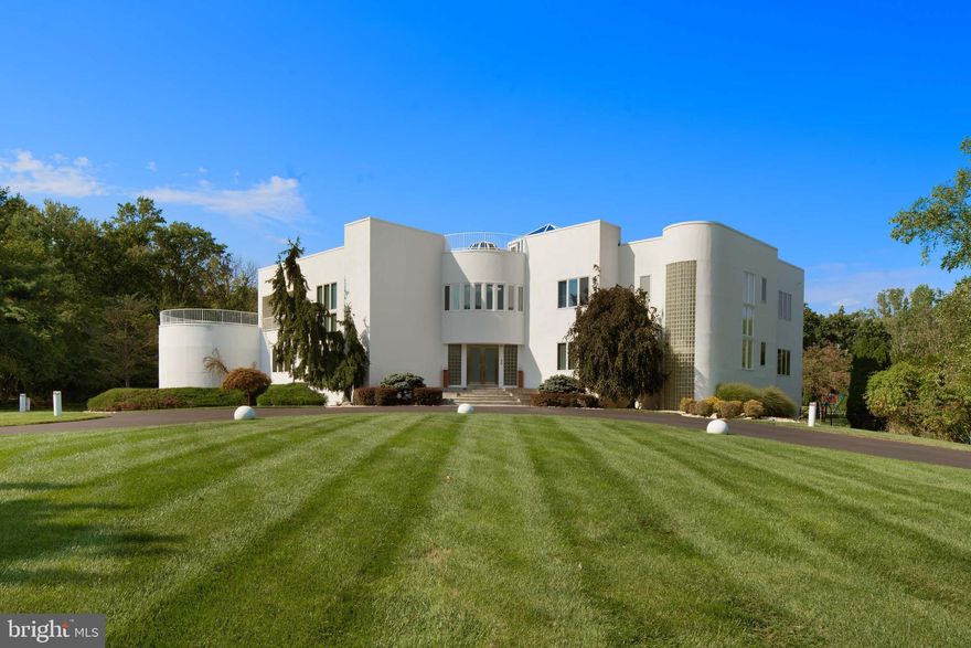 Welcome to 611 Creek Lane, an expansive, light-filled modern residence that blends sleek design with refined luxury. This sun-drenched home is crafted for both entertaining and comfort, with extensive windows and sophisticated details in every space. Enter through a striking two-story foyer, where marble floors and a sweeping double staircase create an unforgettable first impression, illuminated by a domed skylight. To the left, a living room with a conversation pit exudes retro charm, leading to a mirrored dining room that amplifies light and space. At the heart of the home is a cook's kitchen with a unique built-in aquarium at the peninsula, a wet bar, and ample cabinetry and shelving. Outfitted with high-end Thermador and Gaggenau appliances, including a commercial induction range, double ovens, and a steam griddle, this kitchen is made for serious culinary work and relaxed entertaining. Adjacent to the kitchen, a circular breakfast nook opens into the family room with a textured accent wall, fireplace, and access to a sunlit circular sunroom—a serene reading spot to relax while looking over the pool. Completing this level is a first-floor bedroom suite with a walk-in closet and marble ensuite, an office, and a powder room. An additional bedroom suite located off the kitchen can function as an au pair or in-law suite. Upstairs, the primary suite is a private haven, featuring a gas fireplace, wraparound balcony, and wet bar with a beverage fridge. The spa-inspired ensuite includes a sunken Jacuzzi tub by a fireplace, a walk-in shower, and expansive views of the lush backyard. A large walk-in closet with built-ins, a secure safe room, and a dressing area add both style and functionality. An adjoining sitting room with a staircase leads to a one-of-a-kind third-floor atrium with rooftop deck access. Across the hall, a second-floor office with its own balcony creates an inspiring workspace. Three additional bedroom suites each have walk-in closets and private bathrooms, with one suite featuring a private balcony. A secondary staircase leads to the walk out finished basement space with backyard access, ideal for hosting or private relaxation. This level includes a secondary kitchen with bar seating, a private bedroom suite, a full hall bath, and abundant storage. The backyard is an entertainment oasis, with multi-level patios shaded by mature trees, a heated in-ground pool, hot tub, and built-in barbecue with grill and sink. Fully fenced, this secluded space offers both privacy and style. Located minutes from upscale shopping and dining in Flourtown and Chestnut Hill, 611 Creek Lane offers tranquil living with nearby access to the scenic and award-winning trails of Fort Washington State Park. Discover the balance of elegance, modern innovation, and privacy at 611 Creek Lane—a home designed for the discerning.