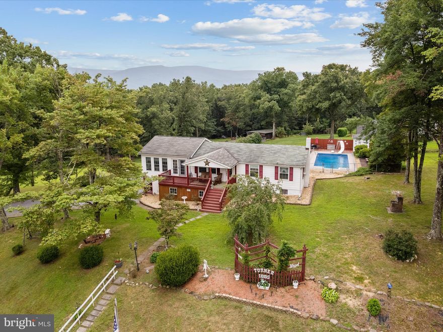 This charming 3-bedroom, 2-bath home offers 1,300 sq ft of main-level living space, with additional 1,000 finished square footage in the walkout basement—perfect for multi-generational living or entertaining guests. Inside, you'll find a spacious layout featuring a large sunroom, ideal for enjoying the surrounding nature all year long, a kitchen/dining combo, expansive living room, and 3 nicely sized bedrooms that share a full hall bathroom. The finished basement includes a recreation room with dry bar offering versatile space for extended stays or recreational use, bonus room with woodstove, an additional bonus room that could be used as a 4th bedroom, laundry room with plenty of storage space,  and another full guest bathroom. Step outside and be amazed by the outdoor amenities: a sparkling in-ground pool, multiple sheds for storage or hobbies, a large covered front porch, a rear deck for grilling out, and a beautifully maintained yard perfect for relaxation or gatherings. Whether you're hosting summer pool parties or enjoying quiet country mornings on the porch, this property has it all. Located just a short drive from Winchester and major commuter routes, this home combines the best of privacy, functionality, and location. Experience peaceful living with room to grow at 1885 Carpers Pike!