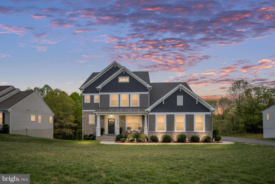 Welcome to the perfect blend of modern design, space, and lifestyle in the highly sought-after Liberty Hall community in Stafford, VA. Built in 2022 by Atlantic Builders and set on a private 1.5-acre homesite, this beautifully upgraded home offers the space you’ve been looking for—inside and out—while still being conveniently located to everything Stafford has to offer.

From the moment you arrive, the stone-front exterior and oversized two-car garage with keypad entry create a strong first impression. Inside, the home opens to a light-filled, thoughtfully designed floor plan built for the way people live today. The heart of the home is the stunning gourmet kitchen, featuring a quartz top island with an additional second custom quartz island with added storage, soft-close cabinetry, and a full walk-in pantry that keeps everything organized and within reach. Just off the kitchen, a pocket office provides the perfect work-from-home setup without sacrificing space.

The main living area is warm and inviting, centered around a gas fireplace and an abundance of windows capturing the natural lighting and a scenic view. The morning room adds even more natural light, complete with a ceiling fan and sliding glass door that leads to your outdoor living space. Step outside to the composite deck featuring a built-in bar top, grill bump-out, and lighted stairs—ideal for entertaining or simply unwinding at the end of the day.

Out back, your private retreat continues with a walkout basement leading to a patio and a Hot Springs Grandee saltwater hot tub (2023), designed to comfortably seat up to seven. Whether hosting friends or enjoying quiet evenings under the stars, this space delivers. Enjoy entertaining this summer on your 26 x 12 Trex deck with bar top, and additional grill bump out. 

Upstairs, the primary suite is a true escape, offering two walk-in closets, a massive walk-in shower, and dual vanities with quartz countertops—including a separate additional vanity space for added convenience. One secondary bedroom features a private en-suite, with its own walk-in closet, while the remaining bedrooms share a Jack-and-Jill bathroom with a double vanity also with quartz countertops, providing both functionality and privacy.

The finished walkout basement adds even more versatility, complete with a bedroom and full bathroom, plus an additional room that can easily serve as a guest space, gym, or home office.

This nearly new home offers the rare combination of modern construction, premium upgrades, 9' ceilings on all three levels, and acreage—giving you the privacy you want without sacrificing convenience. If you’ve been searching for a move-in ready home with space to spread out, entertain, and truly enjoy where you live, this one checks all the boxes.
