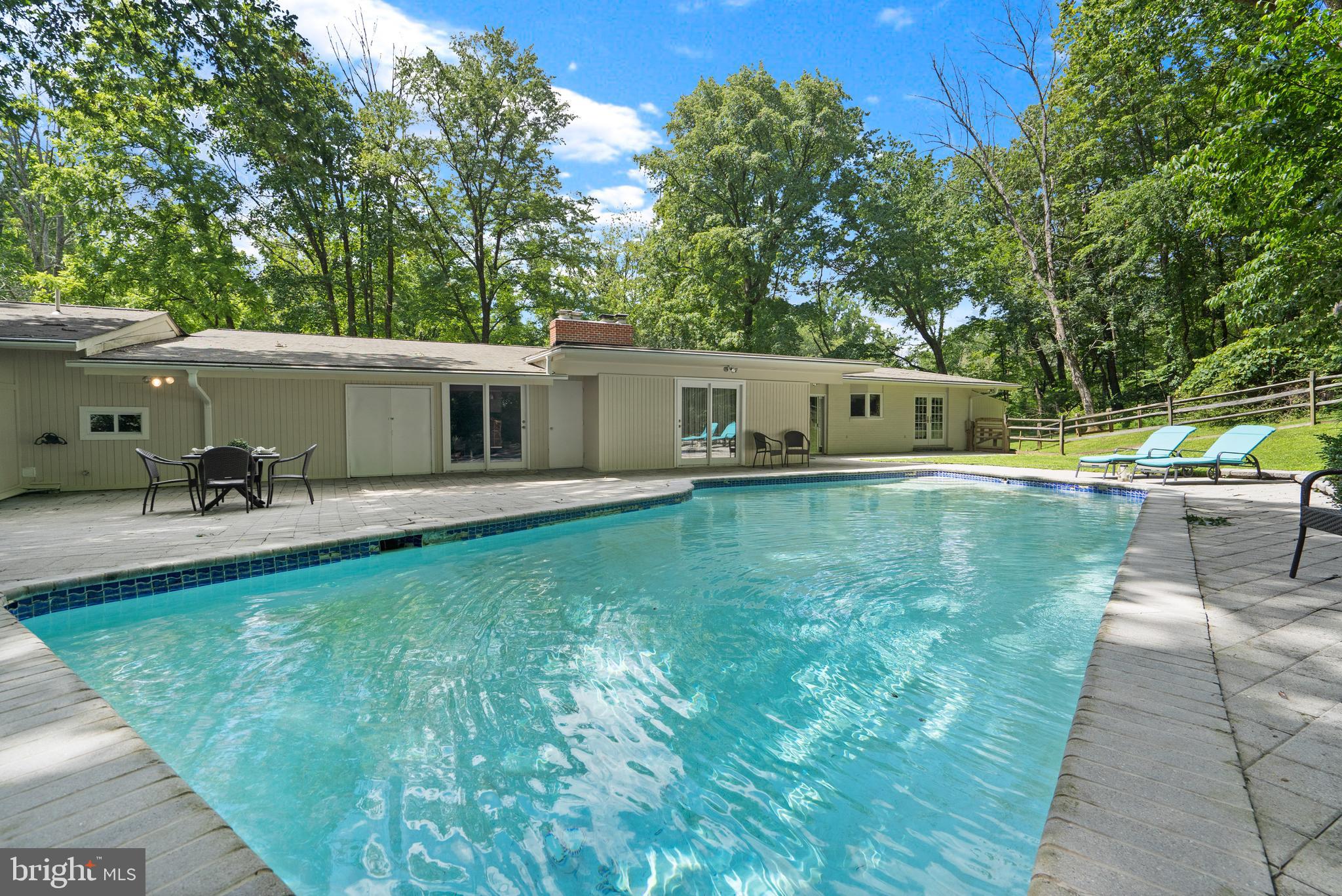 Welcome home to the Caves Park Community. This mid century modern home is nestled on over two and a half acres of a remarkably private and serene wooded lot. Sip your morning coffee on the covered porch overlooking the lush front yard perfectly distanced from the main road so you can enjoy in peace without losing convenience. As you enter, endless charming details captivate you. High vaulted ceilings with exposed wood beams, wide open living room with fireplace, and exposed brick are just a few of the many features. The spacious eat-in kitchen is perfect for crafting your next chef-like meal, detailed with granite countertops and backsplash, island and cabinet space galore. The primary suite features a walk in closet and updated ensuite bathroom embellished with a jetted tub and other spa like features. The additional bedrooms are sizable for family and friends or can be used as your home office. The finished basement is a great place for a recreation area, perfect for entertaining, watching a movie, or your favorite tv show. A significantly sized mud room/laundry area, ideal for storage, leads to the oversized three car garage; a dream come true to a car enthusiast, complete with a work bench, built-in shelves and more than enough space for multiple cars. The airy den gives you access to the amazing patio. Relax, retreat and cool off on hot summer days to your own oasis, enjoying the in-ground pool, soaking the sun rays up or enjoy ample shade provided by the lush greenery surrounding you from the fenced in backyard. Conveniently located near 759, 695 and 83. Schedule your showing today!