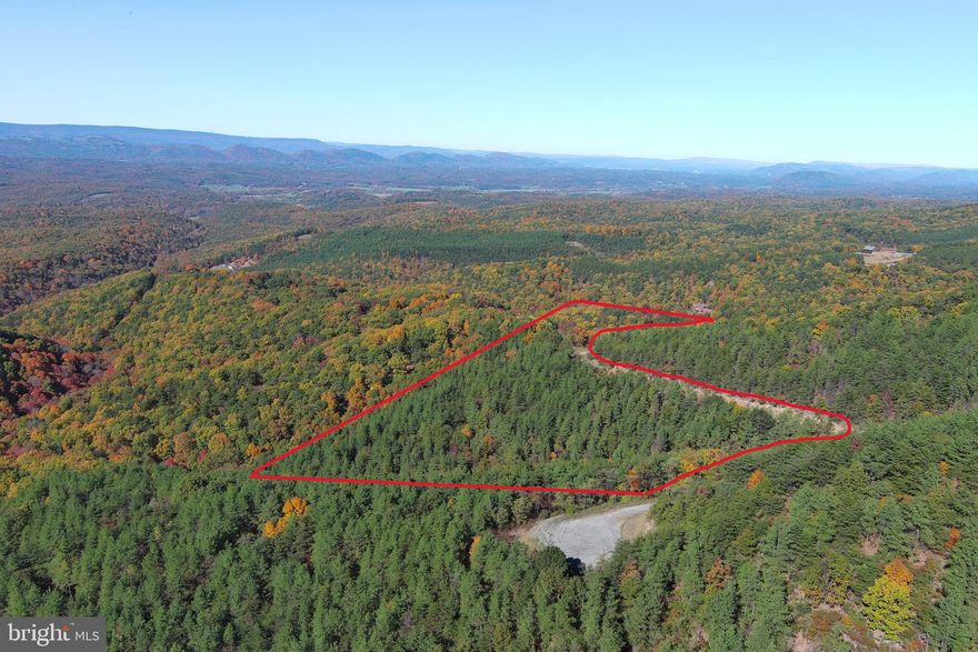 DOUBLE VISION.....20 PRIVATE WOODED ACRES WITH DOUBLE THE PANORAMIC PLEASURE, OFFERING PREMIUM LONG RANGE LAYERED VIEWS TO THE NORTH AND STRAIGHT LINE SUNSETS TO THE WEST. BRAND NEW CLEARED BUILDING SITE/RV PAD GIVES YOU A HEAD START ON BUILDING YOUR DREAM AND SAVES YOU AT LEAST 10K $$$$ ON INFRASTRUCTURE COSTS. UNLIKE MOST PREMIUM VIEW LOTS, YOU CAN ACTUALLY USE THE MAJORITY OF THIS ONE......RE CLEARED OLD LOGGING ROAD RUNS 1500 FT THROUGH THE PROPERTY, PROVIDING EASY ACCESS TO GET THAT BIG BUCK OR BEAR OUT OF THE TIMBER AND ATV FUN PATH.  EASY TO GET TO BUT HARD TO FIND.....BURRIED IN A REMOTE CORNER OF THE COMMUNITY AT THE DEAD END OF THE ROAD FOR MAXIMUM PRIVACY, PEACE AND QUIET. LOCATED IN THE PRESTIGIOUS GATED COMMUNITY OF "THE BLUFFS ON THE POTOMAC".....THE BLUFFS IS KNOWN FOR IT'S ABUNDANCE OF BIG BUCKS, BEAR & TURKEY. AS AN ADDED BONUS, THE COMMUNITY HAS IT'S OWN PRIVATE COMMON AREA ON THE SOUTH BRANCH OF THE POTOMAC RIVER FOR CANOE, KAYAK, TUBES, FISH & SWIM......A PRIVATE PARK ON THE RIVER FOR YOUR SUMMERTIME ENJOYMENT. BUILD, CAMP, HUNT, HIKE, ATV'S, SHOOT......ENDLESS OUTDOOR ACTIVITIES AT YOUR FINGERTIPS.....A STUNNING PROPERTY THAT'S READY TO ENJOY....LET 2024 BE THE YEAR THAT YOU DO SOMETHING FOR YOURSELF AND START SLOWING DOWN YOUR PACE....IT CAN ALL START ON THIS PROPERTY.....PICK UP THE PHONE, MAKE THE CALL, COME FOR A VISIT AND SEE WHAT YOU'VE BEEN MISSING!