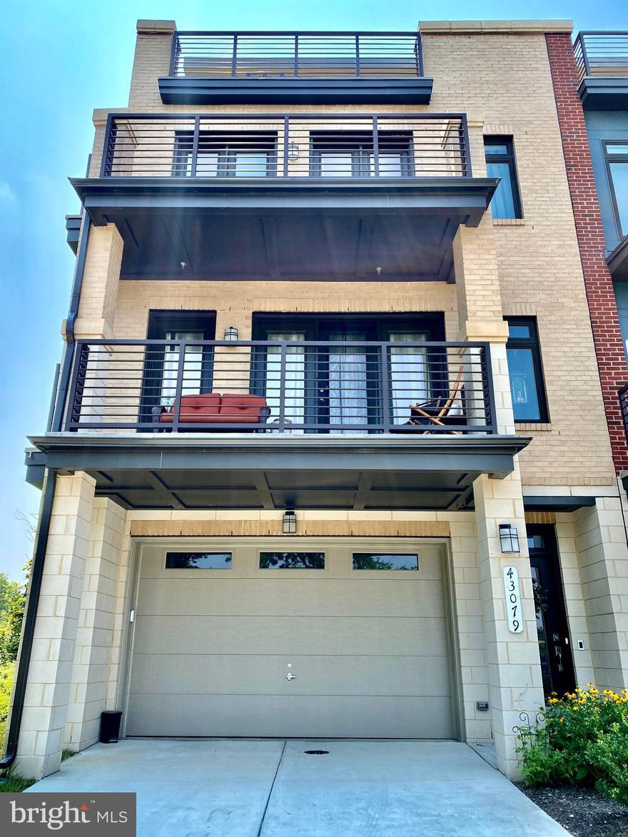 This spectacular end-unit ELEVATOR townhome is nestled between One Loudoun, Lansdowne, and Leesburg, allowing for easy access to the Dulles Toll Road, Route 7, and Route 28. This location provides the ultimate convenience so that you can easily enjoy all of Loudoun’s amenities. This home boasts four gorgeous levels of living with high-end upgrades and top-of-the-line finishes. True luxury is achieved with a private, state-of-the-art elevator, allowing for convenient access to all four levels of the home. As you enter the first level through the two-car garage, you will find a custom-made dog wash, complete with quartz countertops, high-end tiles, and Moen fixtures. The first level also includes a half bath and elevator access. As you walk up to the main-living level, you are greeted with the hub of the home--the gourmet mid-kitchen, outfitted with an oversized island, beautiful quartz countertops, and KitchenAid appliances. To the left of the kitchen is a cozy gas fireplace, completely encased in stunning white quartzite. The open concept floorplan is perfect for entertaining, especially with the four additional outdoor living spaces. The third level of the home includes a gorgeous master bedroom with private balcony and massive windows. The master bath consists of a dual vanity and an oversized frameless glass shower. On this level you will also find a full bath, and two spacious bedrooms--both larger than your average Ashburn townhome! One of the home’s most unique features is the fourth-level loft. Here you will find another entire living space, complete with a kitchenette, bedroom, and full bath. Leading out from the loft is an unbelievable rooftop terrace, large enough to entertain or to simply relax and enjoy the scenery. You will be amazed at the amount of natural light flooding into the home, not to mention the spectacular sunset views! This impressive townhome will not last long, so make an appointment to see it today! Owner agent.