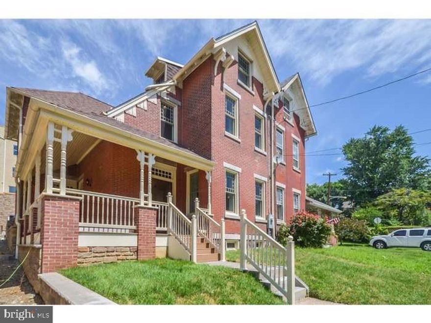 Rent a piece of Philadelphia History with this red brick Queen Anne style twin home with characteristic Eastlake architectural styling. This home was originally built in 1882 and has been fully renovated and restored to its greatness. This architectural gem features 4 bedrooms, 2.5  bathrooms, a fully finished basement and 14 foot tall ceilings on the primary living area. The main level consists of a living room, sitting room, a dining room and a modern kitchen with stainless steel appliances. The main entrance creates a grand center hall with original switchback stairs, in varnished wood carved in the Eastlake style. There is mantelpiece in the main living room with original woodwork and inset tiles with a center tile depicting a scene of the Wissahickon Creek. The second floor consists of three bedrooms, both with ample closet space plus a shared full bathroom and hallway laundry closet. One of the bedrooms was converted into a wardrobe and can remain as is or be taken out and used as a bedroom. The master suite boasts built-in closets, bathroom with dual sink vanity, frameless glass shower and a stand-alone tub with hydrant faucet. The third floor is an open loft bedroom spanning the entire floor with a pitched roof that adds charm. The outdoor spaces include a private back patio area and a large wrap around porch in the front overlooking the garden and front lawn. The front facade is adorned with a restored ornate bracketed cornice with decorative eave returns just below the gabled third floor. The gable contains restored decorative wood elements below and along the eave. The new custom windows were designed to mimic the original wood windows, with classic Queen Anne upper sashes comprised of one large center pane and smaller panes wrapping around it. This historical gem is located in the coveted neighborhood of Wissahickon. This tranquil Philadelphia neighborhood is just a short walk to the Wissahickon park trails & train station with easy accessibility to Manayunk's Main Street, Center City, major highways and the suburbs.  The house can be rented partially furnished.  There is private parking for two cars behind the house.