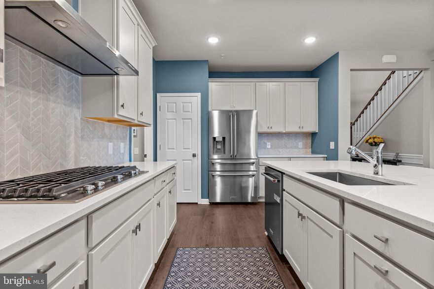 The "Ultimate Flexibility" Home: 1st Floor Primary & More in Jamison, PA! Welcome to 4008 Marquis Lane, a stunning, move-in-ready luxury townhome offering the feel of nearly new construction—without the wait. This exceptional home features high-end upgrades, flexible living spaces, secluded location, and low-maintenance comfort in a highly sought-after community with an outdoor pool, playground, fire pits and walking trails—all within the award-winning Central Bucks School District and just minutes from historic Doylestown. Step into a dramatic two-story foyer where rich hardwood floors extend throughout the main living areas on both the first and second levels. Designed for both everyday living and entertaining, the open-concept main level features an elegant dining area accented by custom wood paneling and a statement chandelier, seamlessly connecting to the gourmet kitchen with a large center island, Quartz Countertops, upgraded ZLINE stainless steel appliances, and abundant cabinetry. Just off the kitchen is a highly functional mudroom with laundry, complete with built-in cubbies and a coat organizer, and direct access to the two-car garage, which is equipped with an EV charger—ideal for modern living.  The home opens to an impressive two-story great room filled with natural light and anchored by a striking fireplace with a dramatic shiplap surround and custom mantel. Sliding doors lead to a deck with built-in privacy shades, overlooking a peaceful walking path—perfect for relaxing or entertaining. Enjoy the convenience of a first-floor Primary suite offering a walk-in closet, ceiling fan, and spa-inspired ensuite bath with double vanities, a glass-enclosed shower with bench, and a private water closet. Upstairs, a thoughtfully designed layout offers incredible flexibility with a spacious loft, a media room ideal for movie or game nights, a bonus room for a home office or flex space, and two generously sized bedrooms with two full baths—perfect for guests or multigenerational living. Additional highlights include custom trim, wainscoting, and accent walls throughout, upgraded lighting, custom interior paint, five ceiling fans with additional mounting locations, a front storm door, and a full unfinished basement offering endless future potential. For added peace of mind, the home includes transferable warranties covering mechanical systems, water infiltration, and structural components. This home delivers modern luxury, thoughtful design, and a vibrant community lifestyle—all without the delays of new construction—making it an opportunity you won’t want to miss.