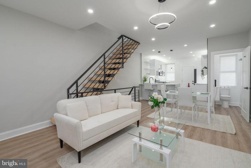 1527 S Napa St is a newly renovated 2-bed, 1.5-bath porchfront home offering a finished basement, a private patio, and central a/c, on a low-traffic block in Philly's Grays Ferry neighborhood. The open main level is bright and airy, framed by high ceilings and luxury flooring. The living room has tall windows and a slat wood feature wall, while a powder room sits off the dining area. The gleaming kitchen is fitted with underlit high-gloss cabinetry, distinctive waterfall countertops, stainless steel appliances, a peninsula with seating, and access to the private patio out back. More living space can be found in the finished basement, along with a large room that's ideal for guests. Up on the second level, you'll find a sunny primary bedroom with an exposed brick wall, a backlit tray ceiling, and a custom closet. Down the hall is a spa-like full bathroom with high-end finishes, a soaking tub, and a multi-jet rainfall shower. Another bright bedroom completes this level. 1527 S Napa St's prime location is close to the Grays Ferry shopping center, eateries, and parks. There's also easy access to public transit, I-76, and University City. Schedule your showing today!