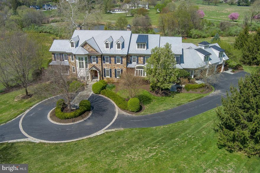 Welcome to 2006 Union Hill Road, an extraordinary custom-built estate offering over 8, 800 sq ft of living space on 10.9 breathtaking acres in sought-after Charlestown Township, part of the French & Pickering Creeks Conservation Trust. Every detail of this 5 Bedroom, 6.3 Bath residence has been thoughtfully designed, blending timeless craftsmanship with luxurious modern amenities. Grand stone entry pillars lead to a private circular drive surrounded by stunning professional landscaping, uplighting, copper gutters, a DuraSlate roof and spectacular outdoor living. Inside, the home showcases hickory hardwoods, 10' ceilings on the main level and extensive millwork including 8-piece crown molding and custom built-ins throughout. The 2-story Foyer opens to elegant formal spaces including a Living Room with woodburning fireplace and a richly appointed cherry-paneled Study. The step-down Family Room features 11’ ceilings, coffered detailing, French doors, and a 2-sided gas fireplace shared with the stunning Kitchen Fireside Den. The gourmet Kitchen features custom cherry cabinetry, Thermador appliances, double islands (one with attached cherry table), walk-in Pantry, Butler’s Pantry, and a dramatic 2-story Breakfast Room. A large Mudroom, Grill Room with beverage center, Family Powder Room, and oversized 3.5-car garage complete the main level. Upstairs, the luxurious Primary Suite includes a Sitting Room, 2-sided gas fireplace, custom designer closet with island, and spa-like Bath with soaking tub, oversized shower, and two linen closets. All additional Bedrooms are ensuite, including a spacious 5th Bedroom/Suite with Sitting Room. A Loft and Laundry Room add convenience. The Third Floor offers both finished and unfinished flexible space and whole-house fan. The daylight walkout Lower Level is designed for recreation and relaxation, featuring a Gym, Media Area, stone fireplace, full Bar, Game Area with pool table, and Half Bath, plus abundant storage. Outside, an exceptional resort-style oasis awaits—an Infinity Edge Pool and Spa overlooking sweeping countryside views, a Bluestone Terrace with stone fireplace and pergola, planter speakers, and two gas grill hookups. The spacious Pool House includes a vaulted Living Area, full Bar with stainless appliances, full Bath, storage room, and its own heating/AC system. Additional highlights include: elevator to all four levels, whole-house generator, central vacuum, radiant heat, new boiler and furnace (2026), holiday lighting outlets with window candles, freshly painted interior millwork, and an interior speaker system. A rare opportunity to own a privately sited, impeccably maintained estate offering exceptional craftsmanship, modern convenience, and unmatched outdoor living in the award-winning Great Valley School District. Also conveniently located to the area’s finest private schools, Great Valley Corporate Center, PA Turnpike and the 202 corridor to KOP and Center City Philadelphia, Paoli Train Station and minutes from the shopping and restaurants of Malvern, Phoenixville and the beautiful Philadelphia Main Line.
