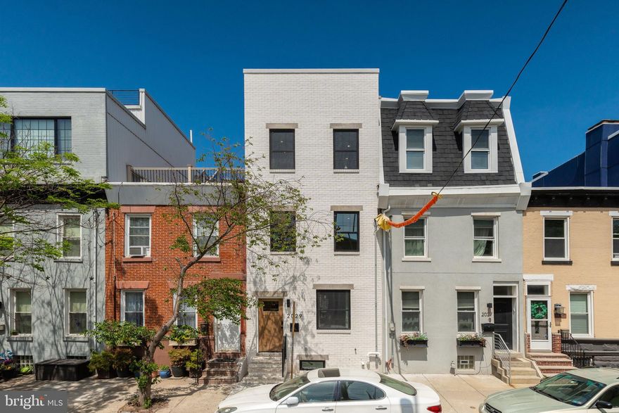 Welcome to 2029 Catharine Street — a luxurious 4 bed, 4 full bath new construction home with parking in the heart of Graduate Hospital. Thoughtfully designed with timeless character and modern amenities, this residence offers the perfect blend of comfort and convenience. Step into the main living space where natural light pours in, highlighting custom arched built-ins and an open floor plan ideal for everyday living or entertaining. The chef’s kitchen features wood shaker cabinetry, sleek quartz counters and backsplash, and a full suite of GE Café stainless steel appliances. Retreat upstairs to your spacious primary suite with a Juliet balcony, walk-in closet, and spa-inspired bathroom. Enjoy generously sized bedrooms, and four full bathrooms spread across the home. Head up to your private rooftop deck and take in panoramic city views—perfect for hosting or unwinding. Additional perks include a fully-finished basement with a bedroom & full bathroom, also a private parking spot in the rear—a rare find in this neighborhood. Located steps from Graduate Hospital favorites like Sidecar Bar, and Ultimo Coffee, 2029 Catharine Street delivers elevated city living with charm, function, and style. 10 Year Tax Abatement included.